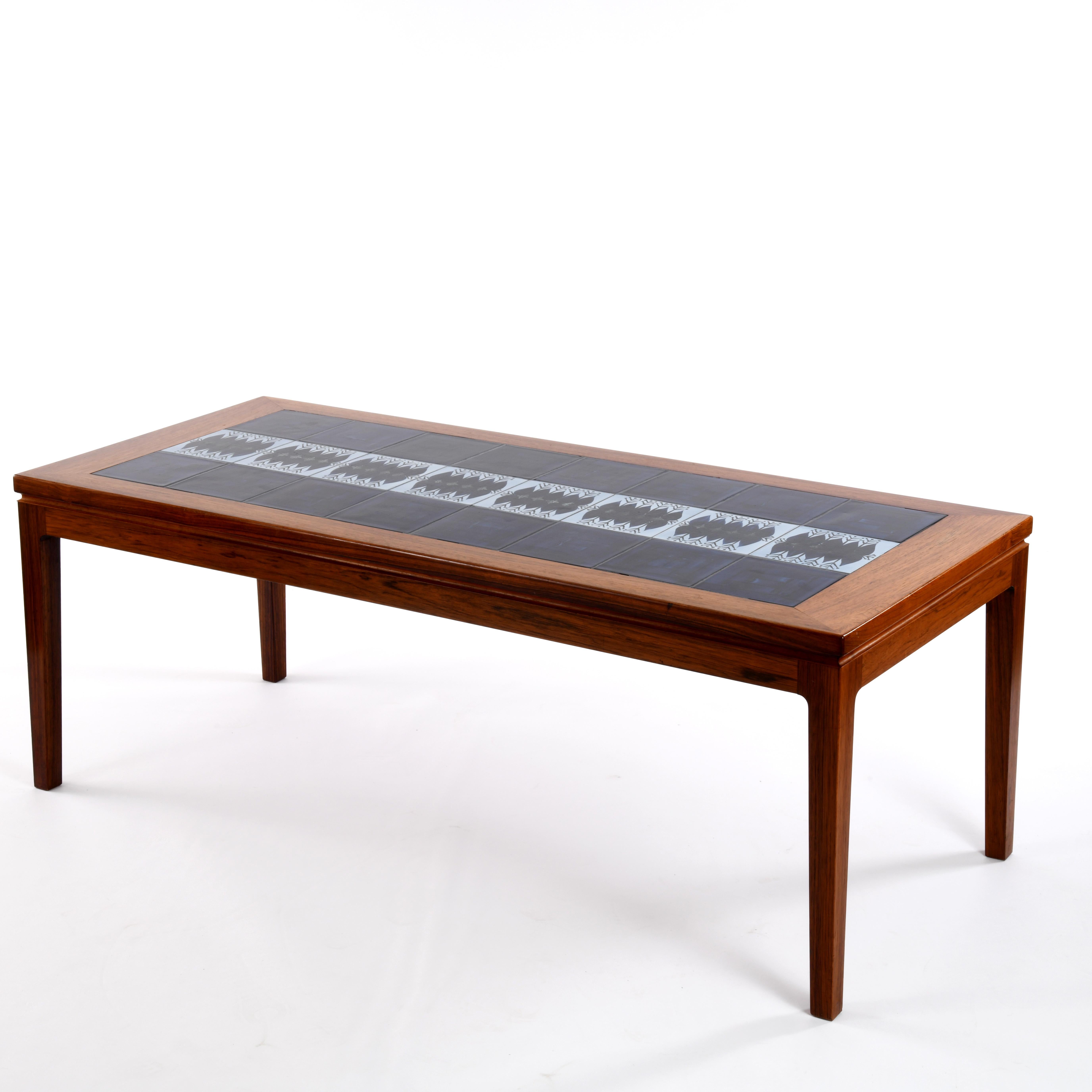 Large coffee table in walnut and ceramic tiles, made in Denmark in the 1950s-60s. It is in very good condition, with beautiful work on the wood surround with an all-round gutter and rounding at the top of the legs in conjunction with the top. The