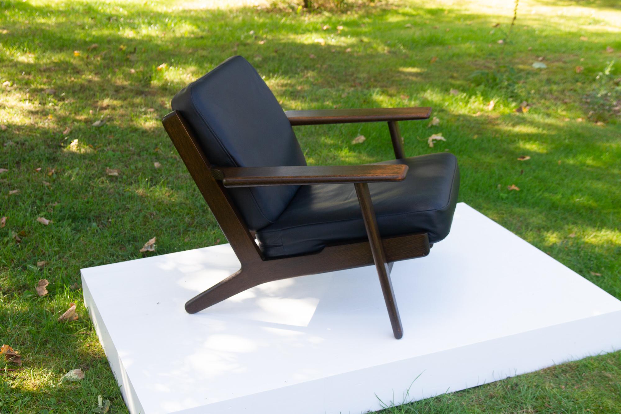Vintage Danish Dark Oak Lounge Chair GE 290 by Hans J. Wegner, 1970s
Mid-century Modern Scandinavian armchair model GE-290 by Hans Wegner for Getama in solid oak. Spring cushions with black leather. 
This easy chair is a true Danish design