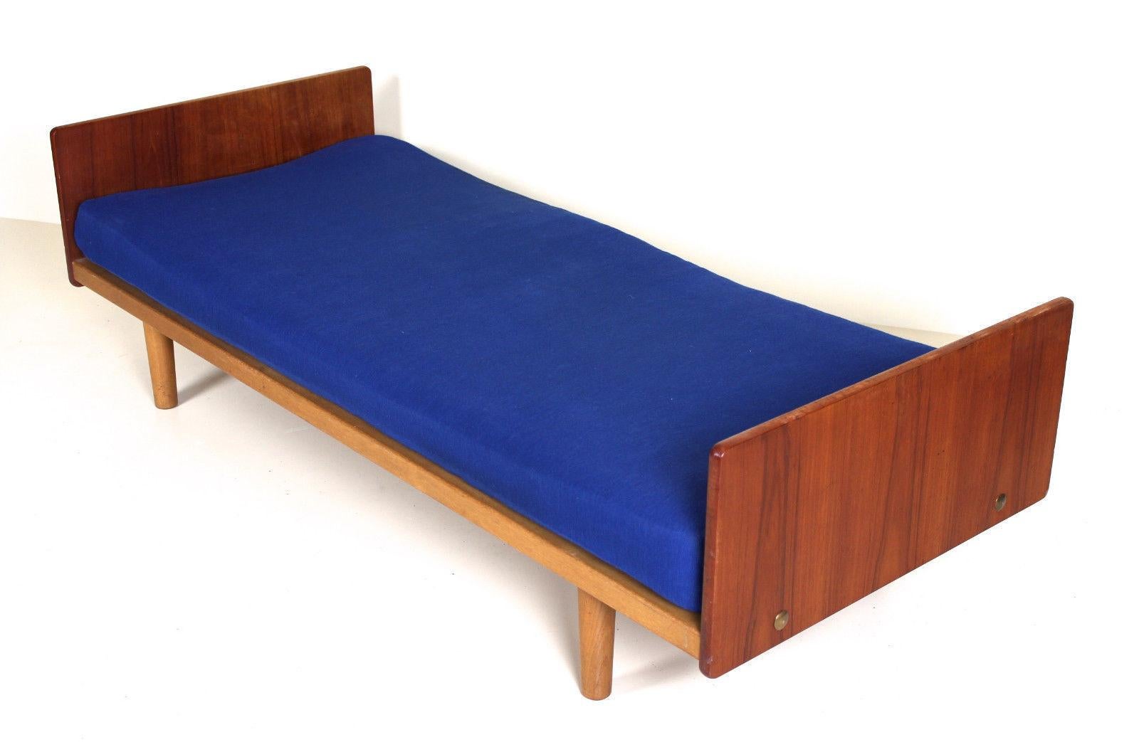A rare opportunity to acquire a Danish mid-20th century day bed.

The cushion upholstered in blue material and framed with teak and raised on light oak round tapered legs.

Complete with storage drawer.