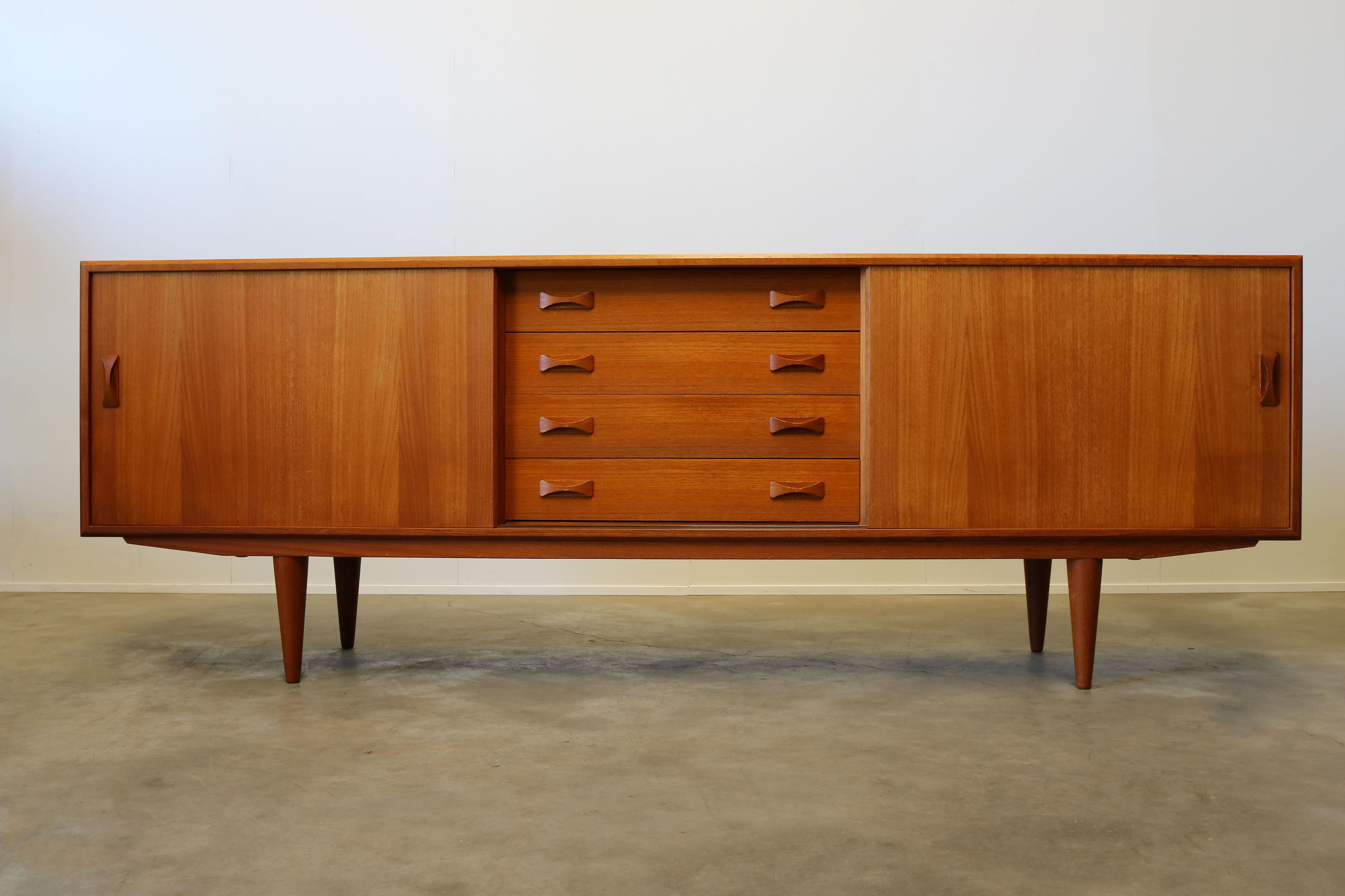 Danish teak sideboard / credenza designed by Clausen & son in the 1960s. Wonderful sculpted handgrips and clean design. The sideboard has four drawers, sliding doors and plenty of storage space. A wonderful example of Danish modern design. Sideboard