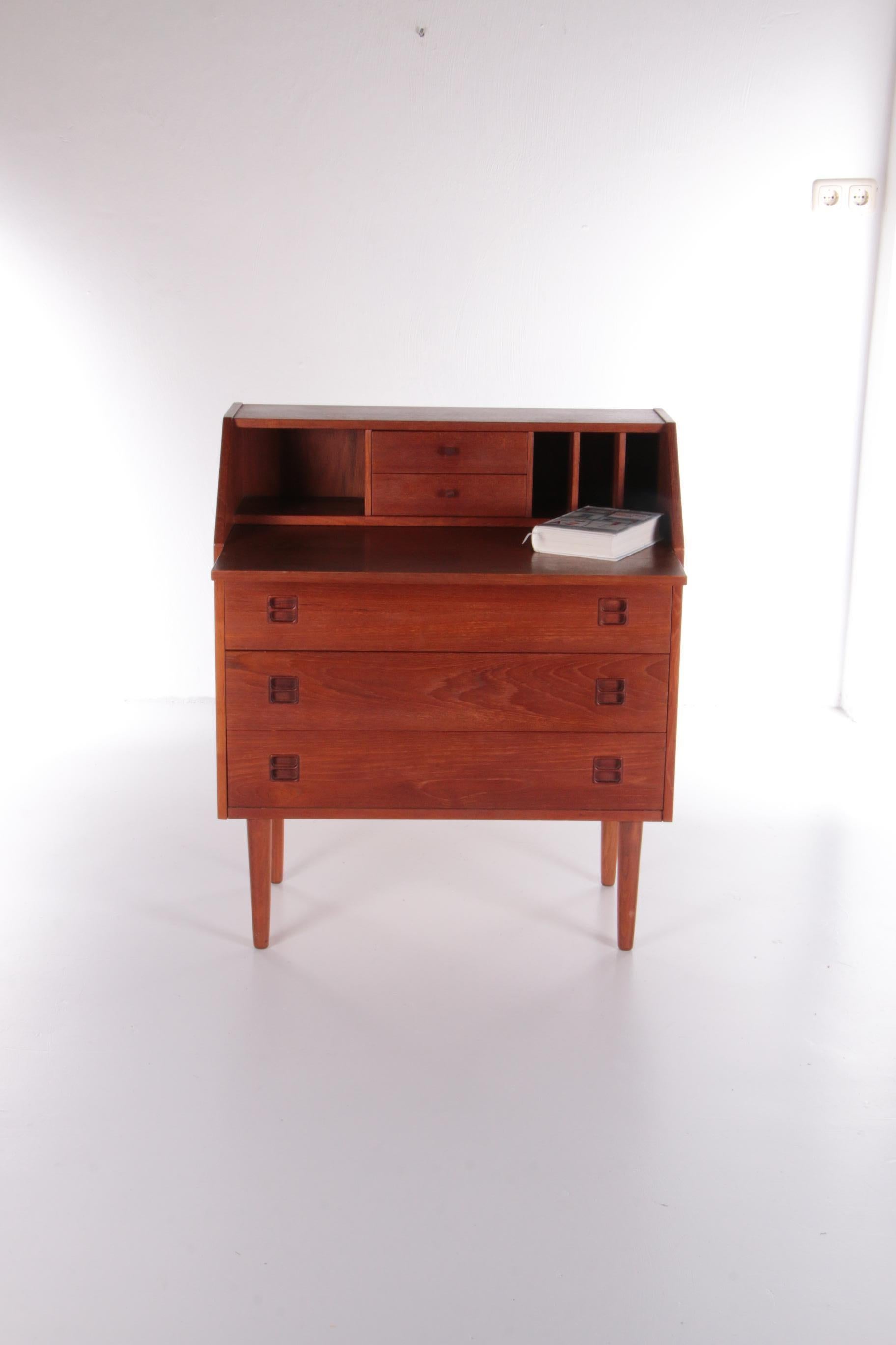 Vintage Danish design teak secretaire produced in the 1960s.

The secretary has a pull-out worktop with 3 drawers and 2 small drawers underneath for extra storage space. The secretary stands on elegant high legs.

With this secretary you can