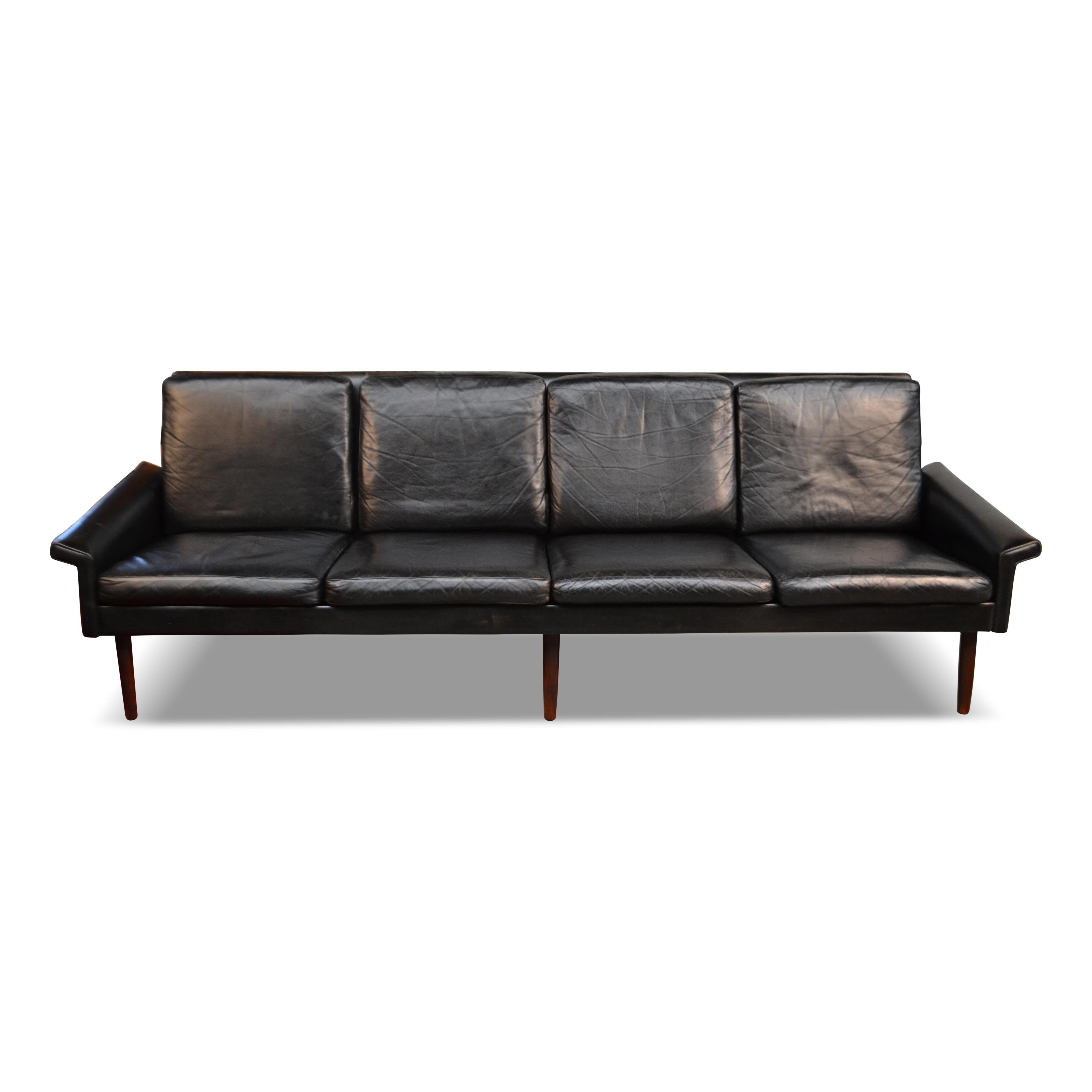Vintage 4-seater leather sofa designed by Danish designer Hans Olsen for C.S. Møbler, Denmark. This rare model features a stylish wooden frame covered with eight leather upholstered cushions. Add instant wow to your vintage or modern interior with