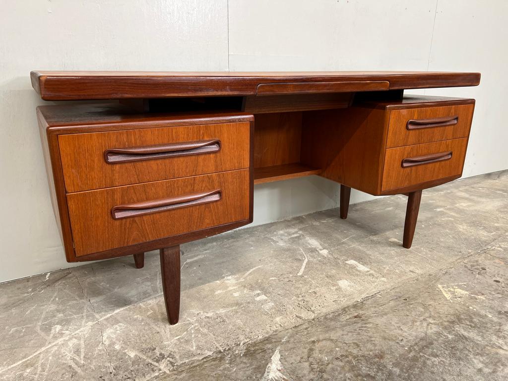 This vintage Danish designed teak floating desk features a slim and organic shape and offers storage possibilities with two double sets of drawers. There is also a cute little 'secret' drawer seamlessly built in to the table top and lined with felt.