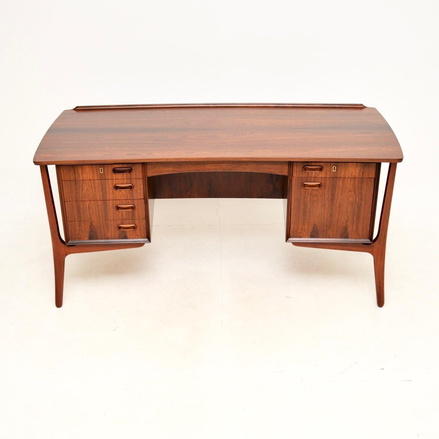 A stunning vintage Danish desk by Svend Aage Madsen for HP Hansen. This was recently imported from Denmark, it dates from the 1960’s.

It is of superb quality and has an incredibly stylish design. The grain patterns and colour tones are absolutely