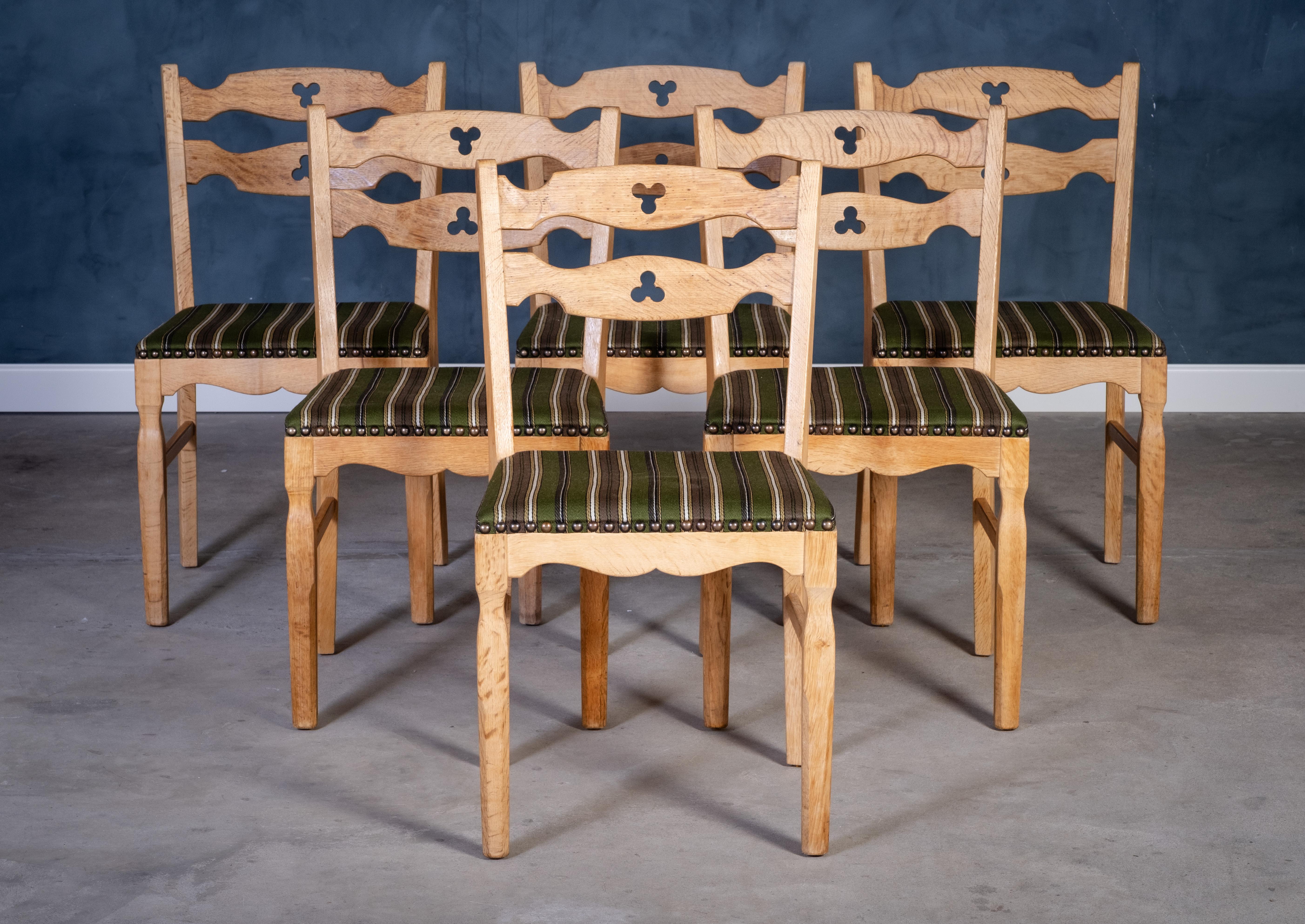 Affascinante set di sei sedie da pranzo in legno massiccio di quercia, realizzato in Danimarca negli anni Cinquanta. Queste sedie sono caratterizzate da splendidi dettagli intagliati e linee eleganti che evidenziano la maestria artigianale del primo