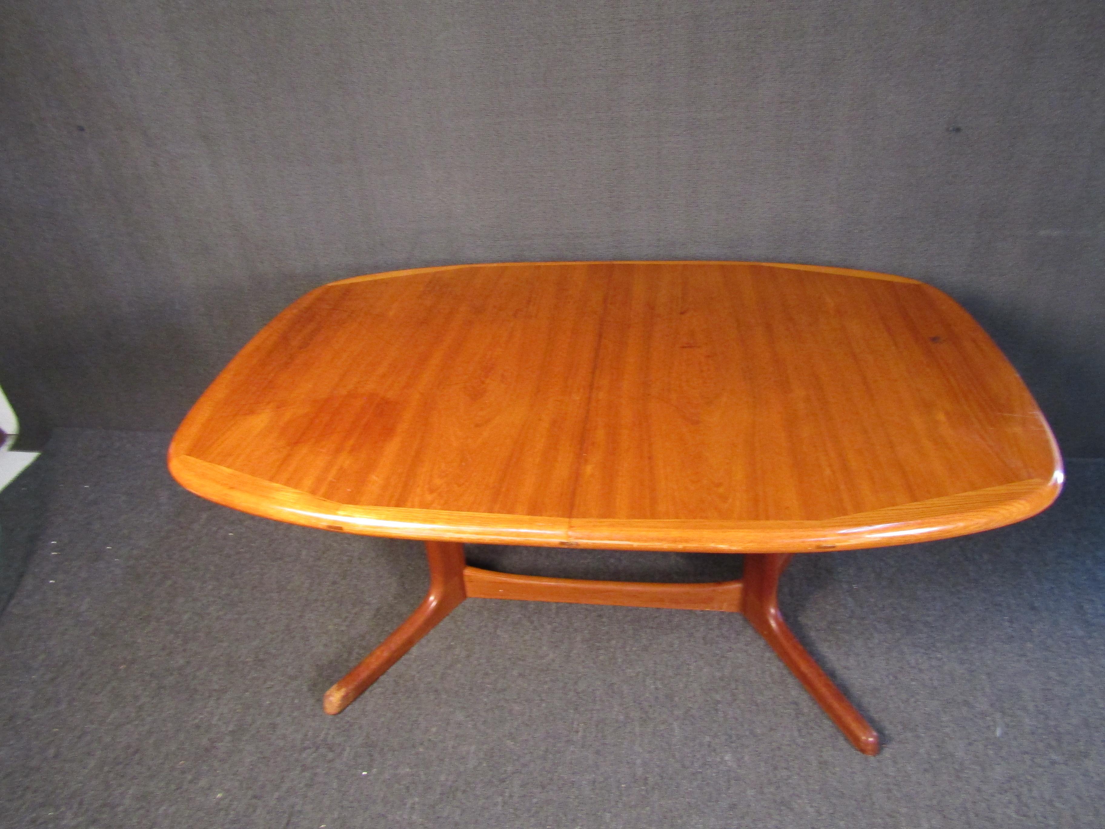 Mid-Century Modern Danish dining table with an impressive and minimal design. Bright teak woodgrain is sure to complement any dining room. Please confirm item location with seller (NY/NJ).