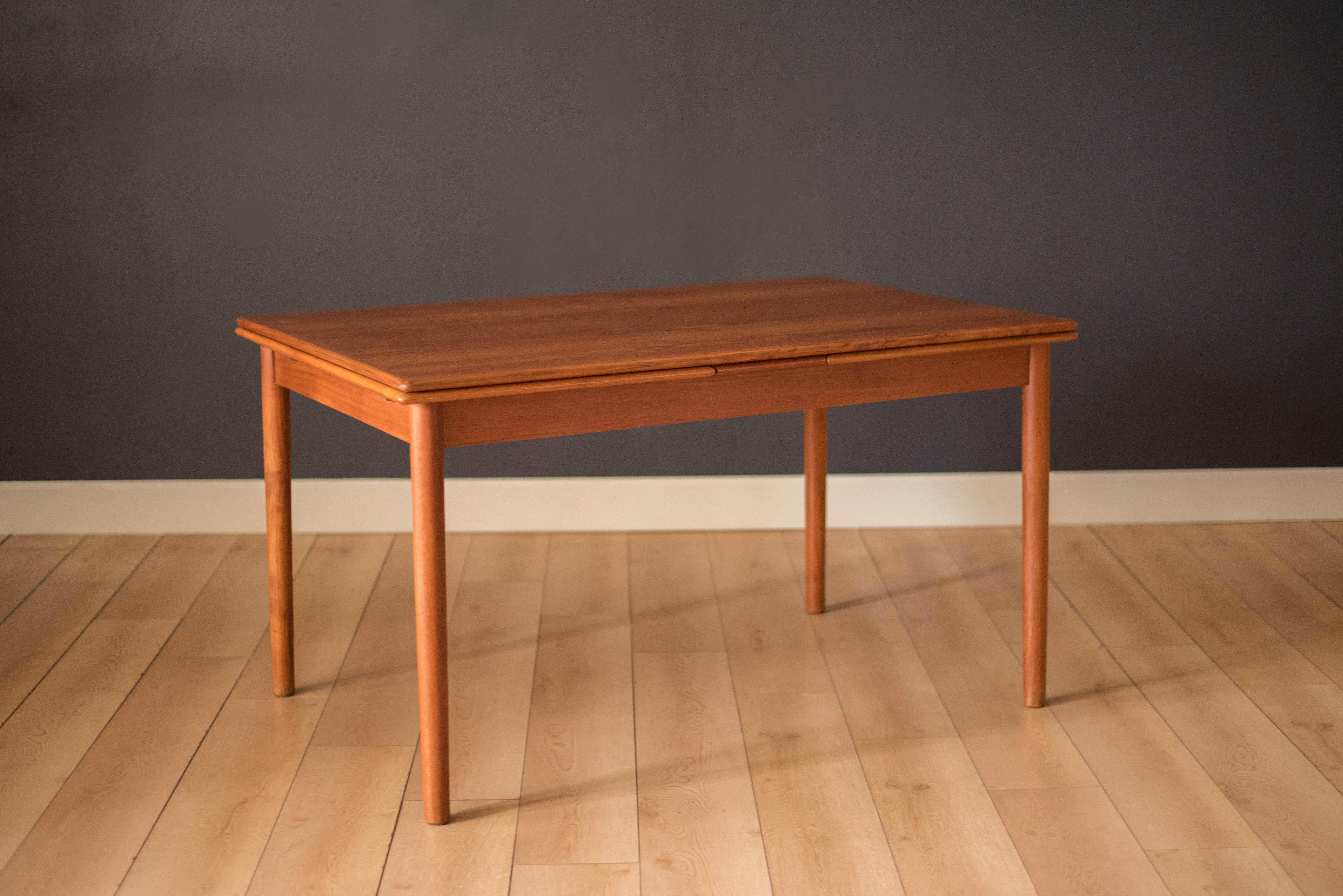 Mid-Century Modern draw leaf dining table in teak manufactured by AM Mobler, Denmark. This simple and Classic piece extends with two leaves that self store underneath the tabletop.

Fully extends to 94