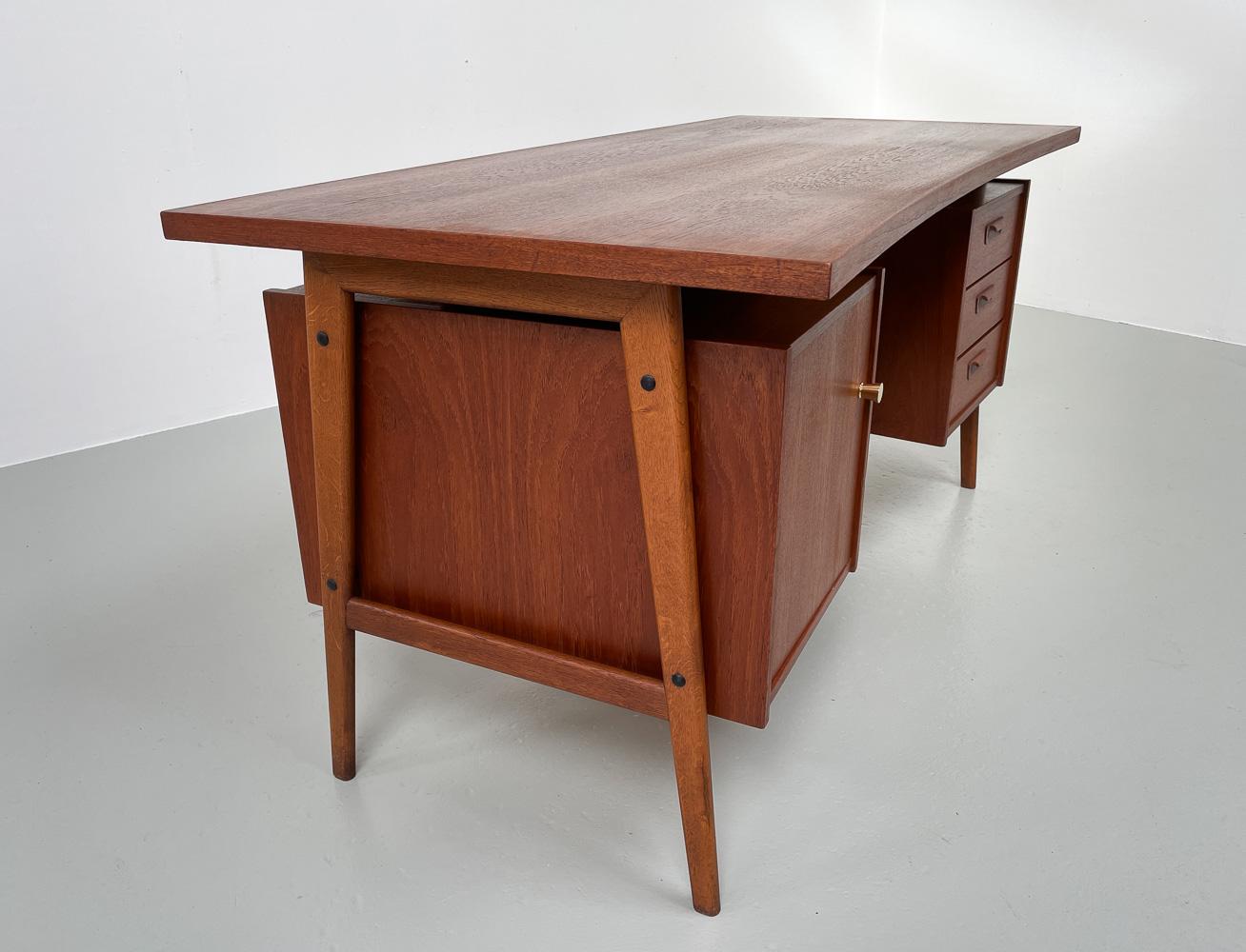 Vintage Danish Freestanding Teak Desk with Floating Curved Top, 1960s.
Scandinavian Mid-Century Modern teak writing desk made in Denmark in the 1960s.
This large unusual executive desk has both a floating and boomerang shaped table top. Slanted