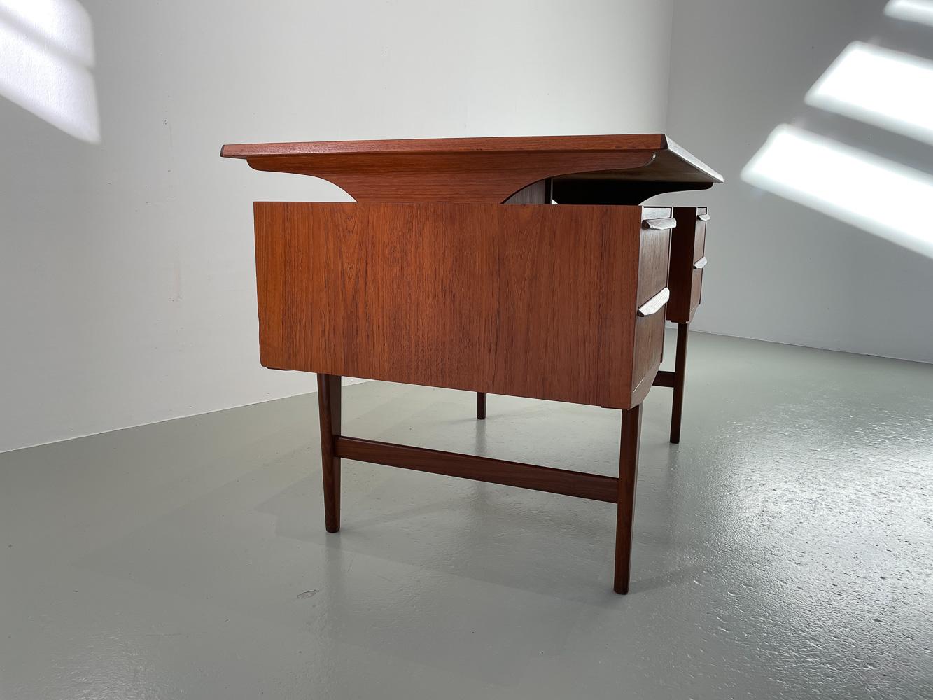 Vintage Danish Freestanding Teak Desk with Floating Top, 1960s.
Scandinavian Mid-Century Modern writing desk in teak made in Denmark in the 1960s.
Features a double pedestal cabinet front with two drawers each. All drawers with full width sculpted