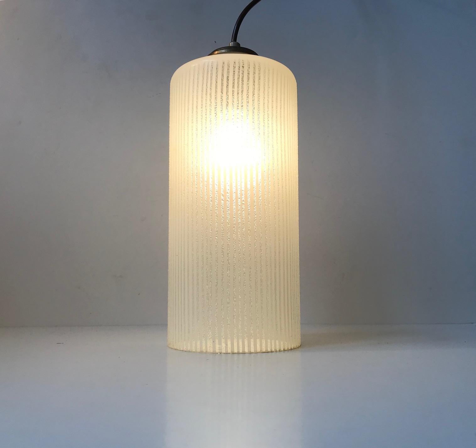 Cylindrical pin-striped pendant lamp. Made from partially frosted hand blown single layered glass. The top is made from brass. Manufactured by Voss in Denmark during the 1950s.