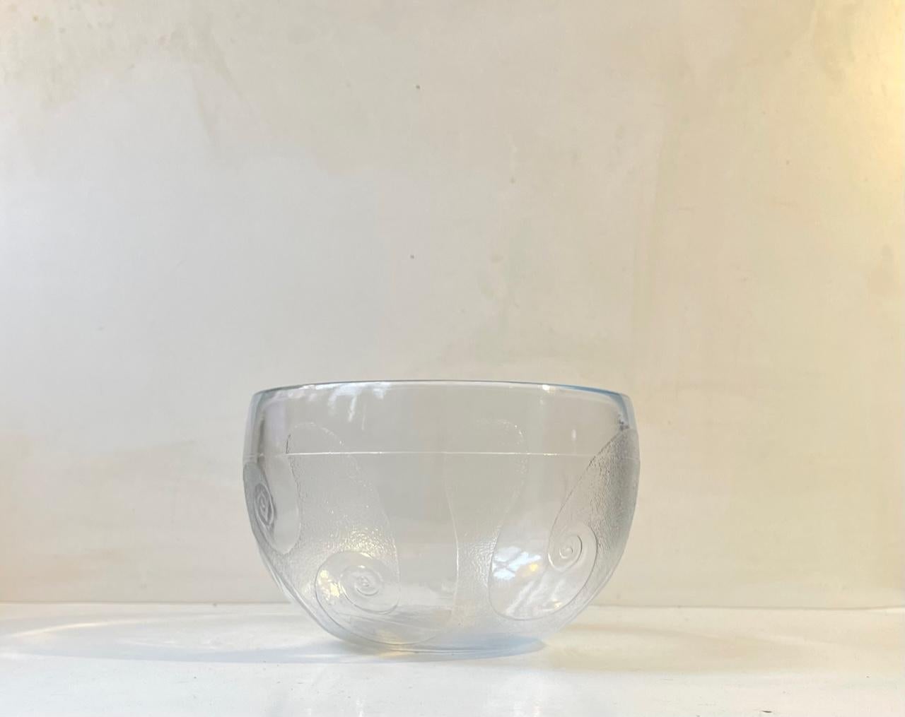 Ein seltener Tafelaufsatz oder eine Salatschüssel aus gegossenem, zentrifugiertem Klarglas. Dekor: Tentakel oder Wellen. Sie heißt Glastronomi (Zusammenstellung von Glas und Astronomie) und wurde 1976 von Michael Bang entworfen und bis 1977 bei
