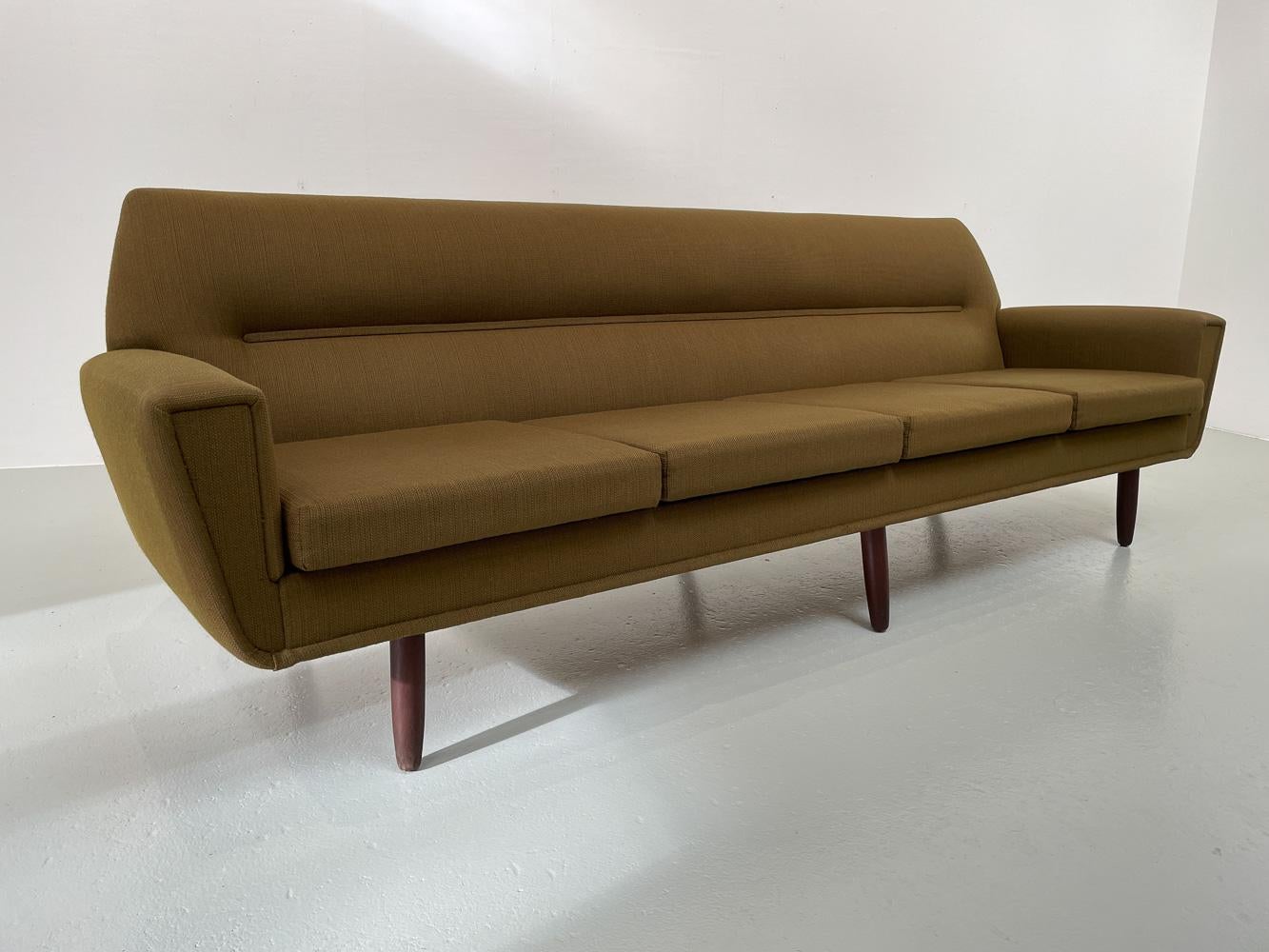 Vintage Danish Green 4-Seater Sofa in Teak and Wool, 1960s.
Mid-Century Modern Danish design 4 seater sofa in original wool upholstery made in Denmark in the 1960s. 
Six round tapered legs. One leg has been replaced with a stained oak leg, other are