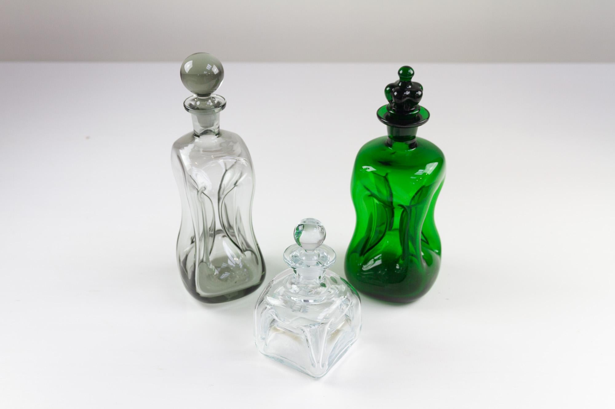 Vintage Danish Kluk Kluk Decanters by Holmegaard, Set of 3.
Set of three hand blown Kluk Kluk decanters from Holmegaard, Denmark 1950s to 1970s. These type of bottles makes a clucking sound when pouring, hence the name cluck cluck.

This set