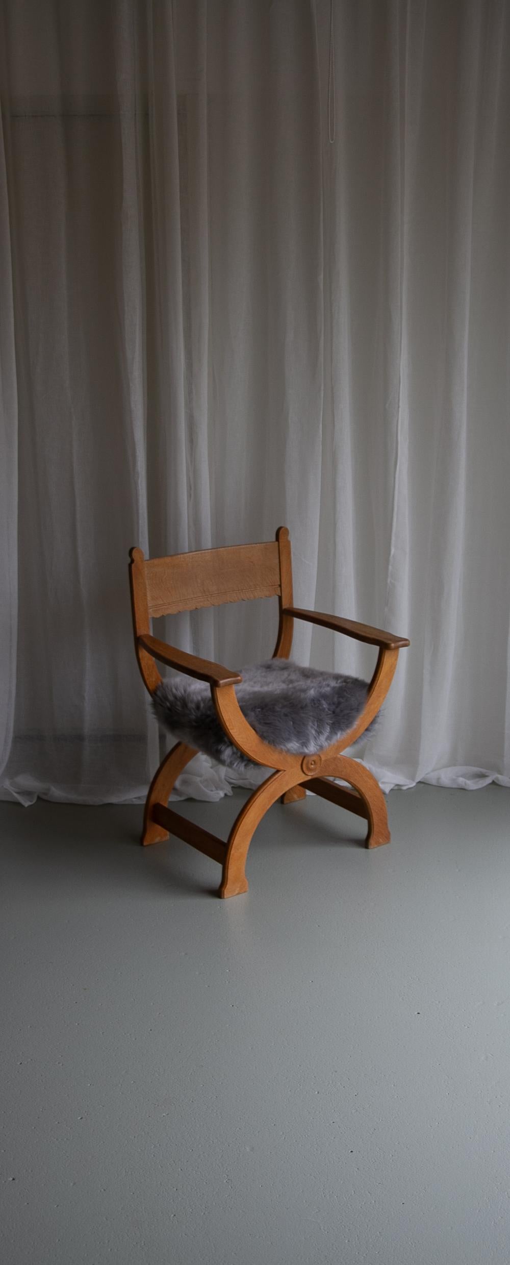 Vintage Danish Kurul Armchair in Oak by Henning Kjaernulf for EG Kvalitetsmøbel, Denmark, 1960s.

This Scandinavian Mid-Century Modern Curule chair in solid Nordic oak model 