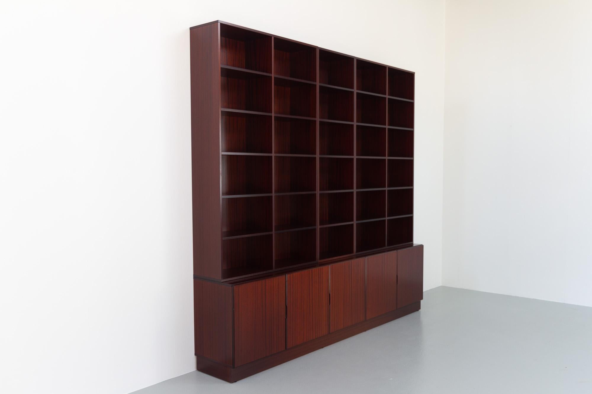 Vintage Danish Large Mahogany 5 Bay Bookcase, 1970s.
Large and impressive Scandinavian Modern 5 bay bookcase in Mahogany veneer. This three part Danish library with plenty of storage space is composed of three cabinets and three bookcases and one