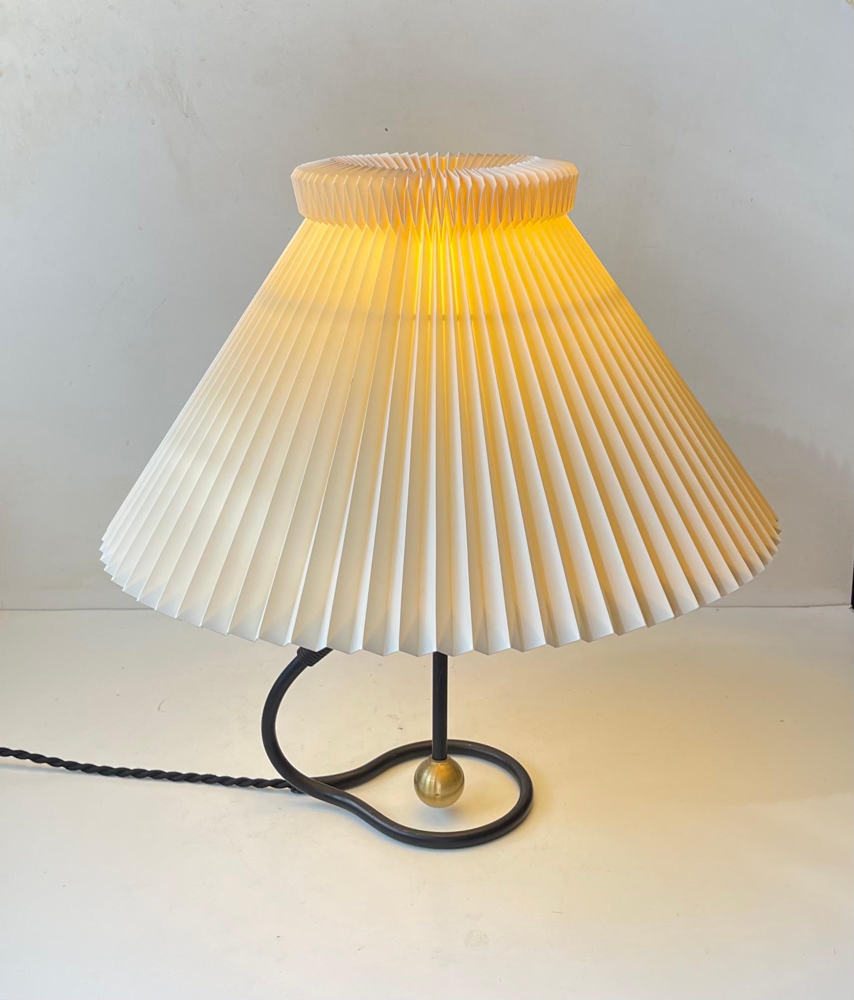 A rare early partially black model 306 table lamp with a base featuring solid brass accents, bakelite socket with on/of switch and a fluted of-white Le Klint paper shade. Designed by architect and professor Kaare Klint in 1945. This example dates