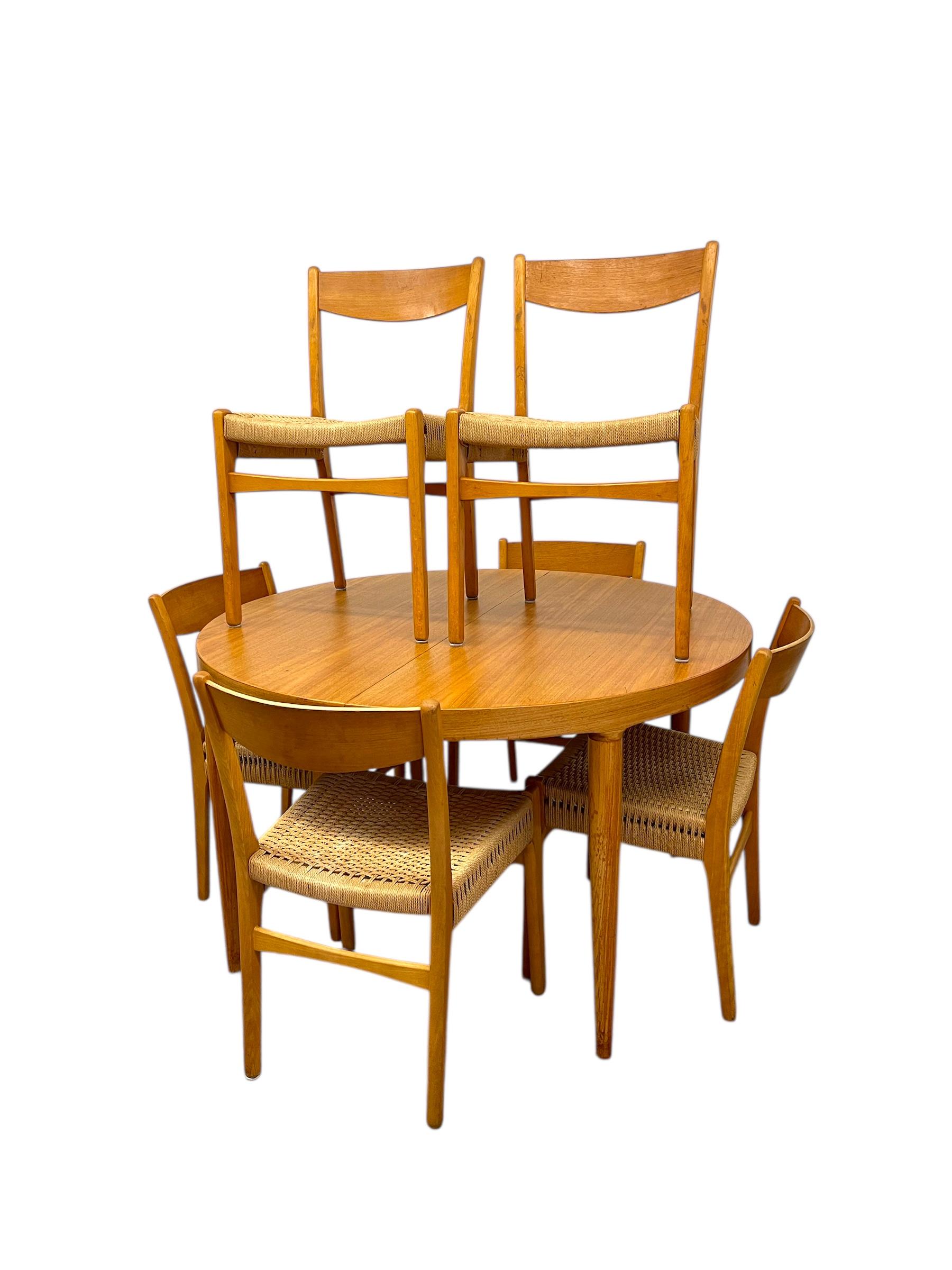 A beautifully cohesive vintage Danish dining set attributed to Skovmand & Andersen for Moreddi, exemplifying the refined craftsmanship and minimalist aesthetic of Mid-Century Modern Scandinavian design.This set includes one round-to-oval extension