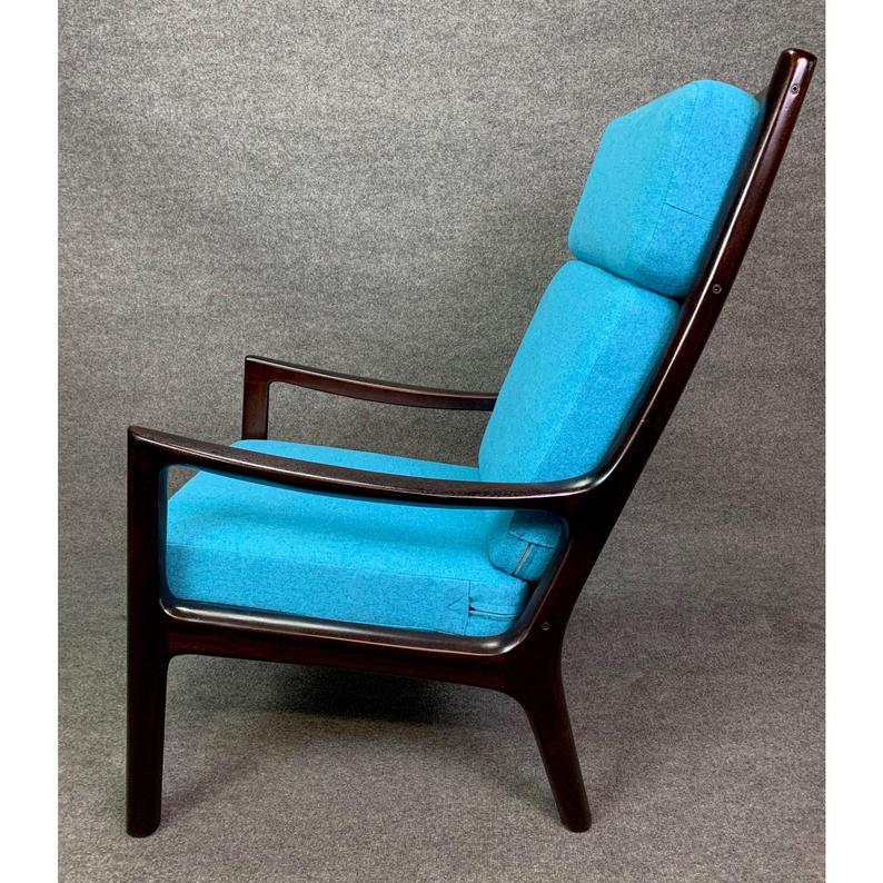 Here is a beautiful Scandinavian Modern high back easy chair designed by master Ole Wanscher and manufactured by Poul Cadovius in Denmark in the 1960s.
This exquisite and comfortable lounge chair, recently imported from Copenhagen to California,