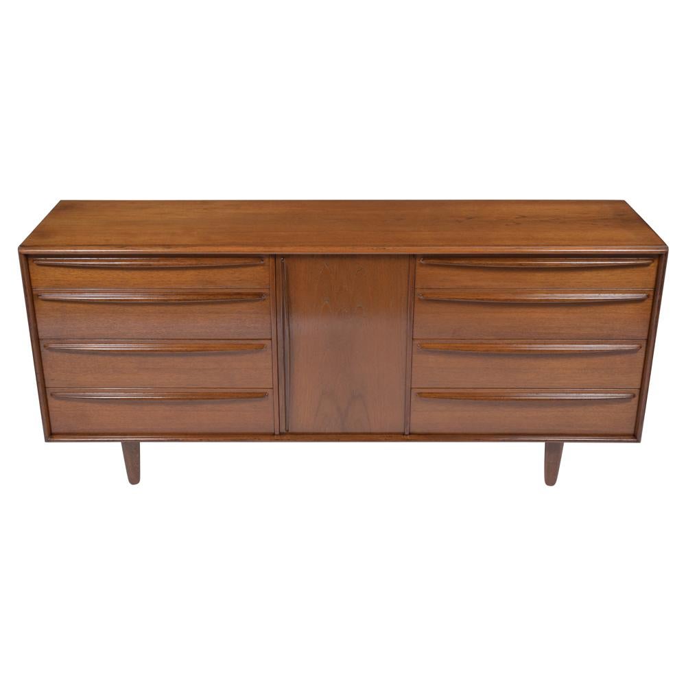 A 1960s mid-century modern danish credenza that has been fully restored by our professional team of expert craftsmen is made out of walnut wood and has been stripped and restained in a rich walnut color with a new semi-gloss lacquered finish. This