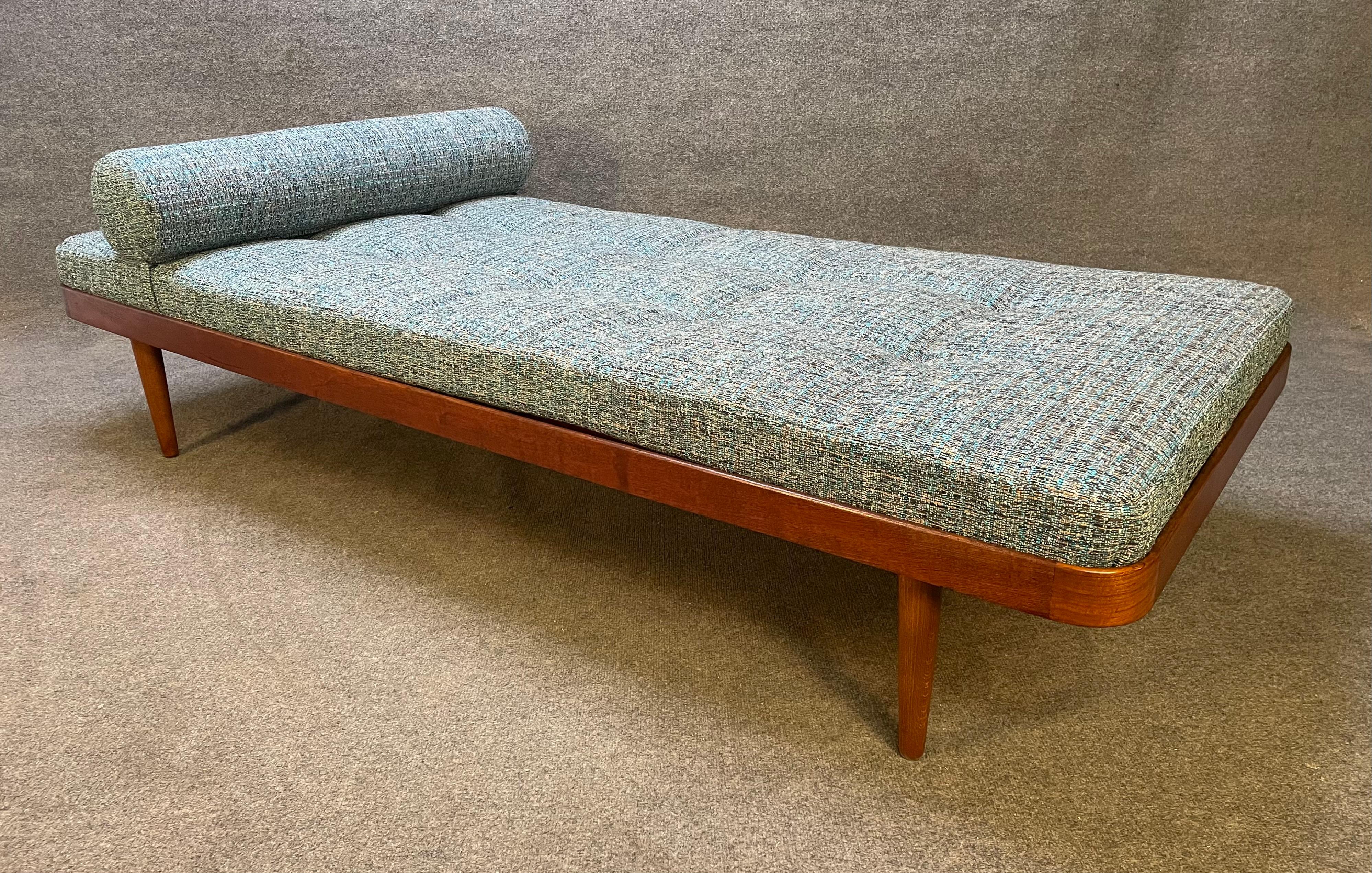 Horsens Mobelfabrik recently imported from Denmark to California before its restoration. This lovely and comfortable piece features a curved teak frame and legs with solid wood slats and a brand new period textured teal-blue-beige tufted upholstery