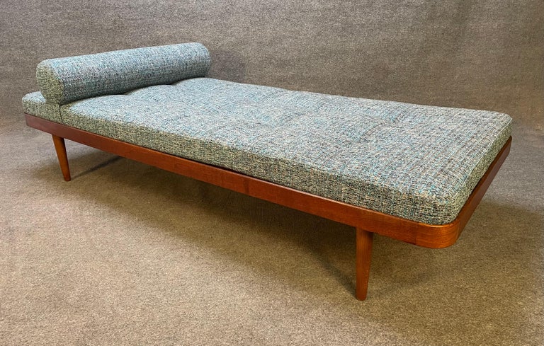 Horsens Mobelfabrik recently imported from Denmark to California before its restoration. This lovely and comfortable piece features a curved teak frame and legs with solid wood slats and a brand new period textured teal-blue-beige tufted upholstery