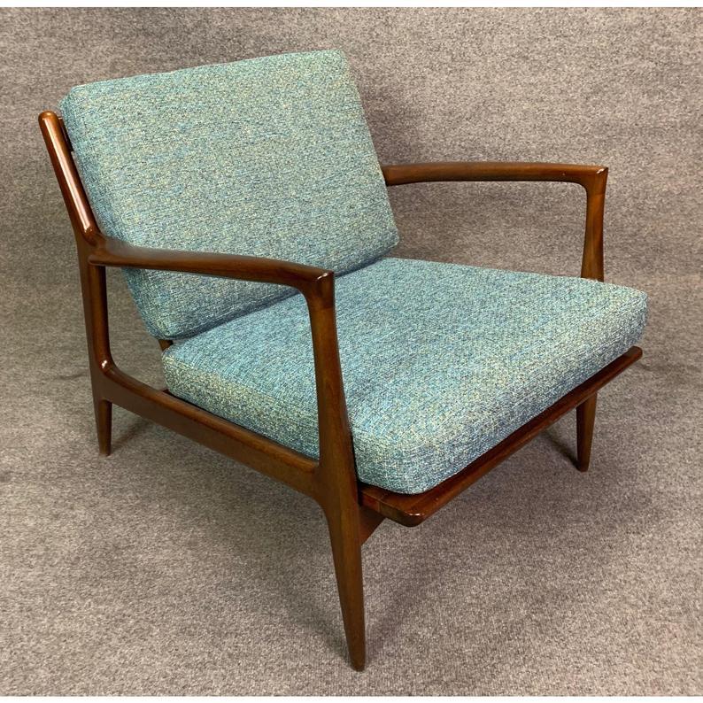 Voici un magnifique fauteuil conçu par Maître Kofod Larsen et fabriqué par Selig Danemark dans les années 1960.
Ce cadre sculptural, nettoyé et huilé à la perfection, est réalisé en bouleau massif teinté noyer. Les coussins sont neufs et ont reçu