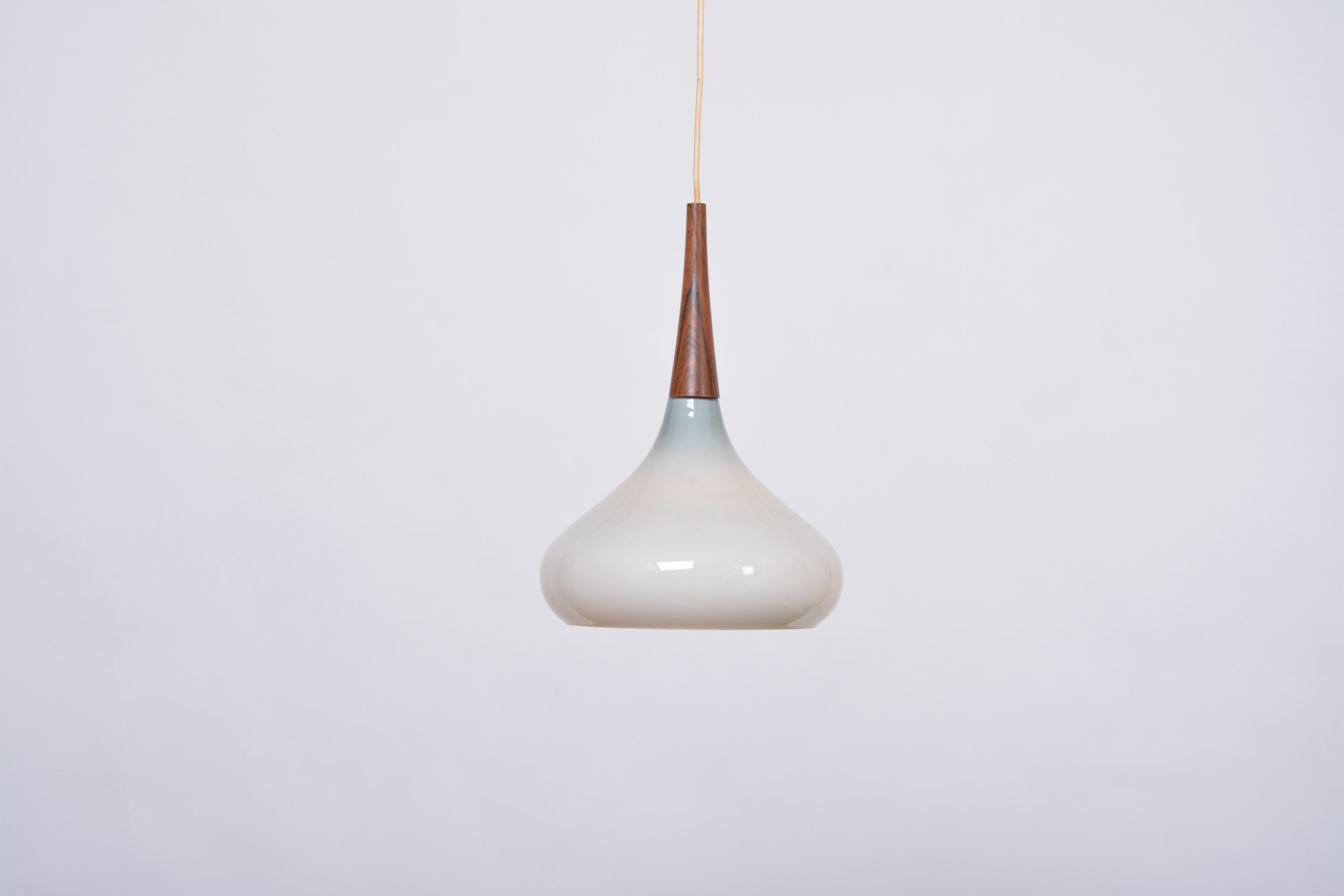 Lampe pendante vintage danoise du milieu du siècle en verre opalin par Holmegaard

Rare suspension en verre opalin blanc soufflé à la bouche, produite dans les années 1960 au Danemark par Holmegaard. Ce pendentif est une ode à l'artisanat. La forme