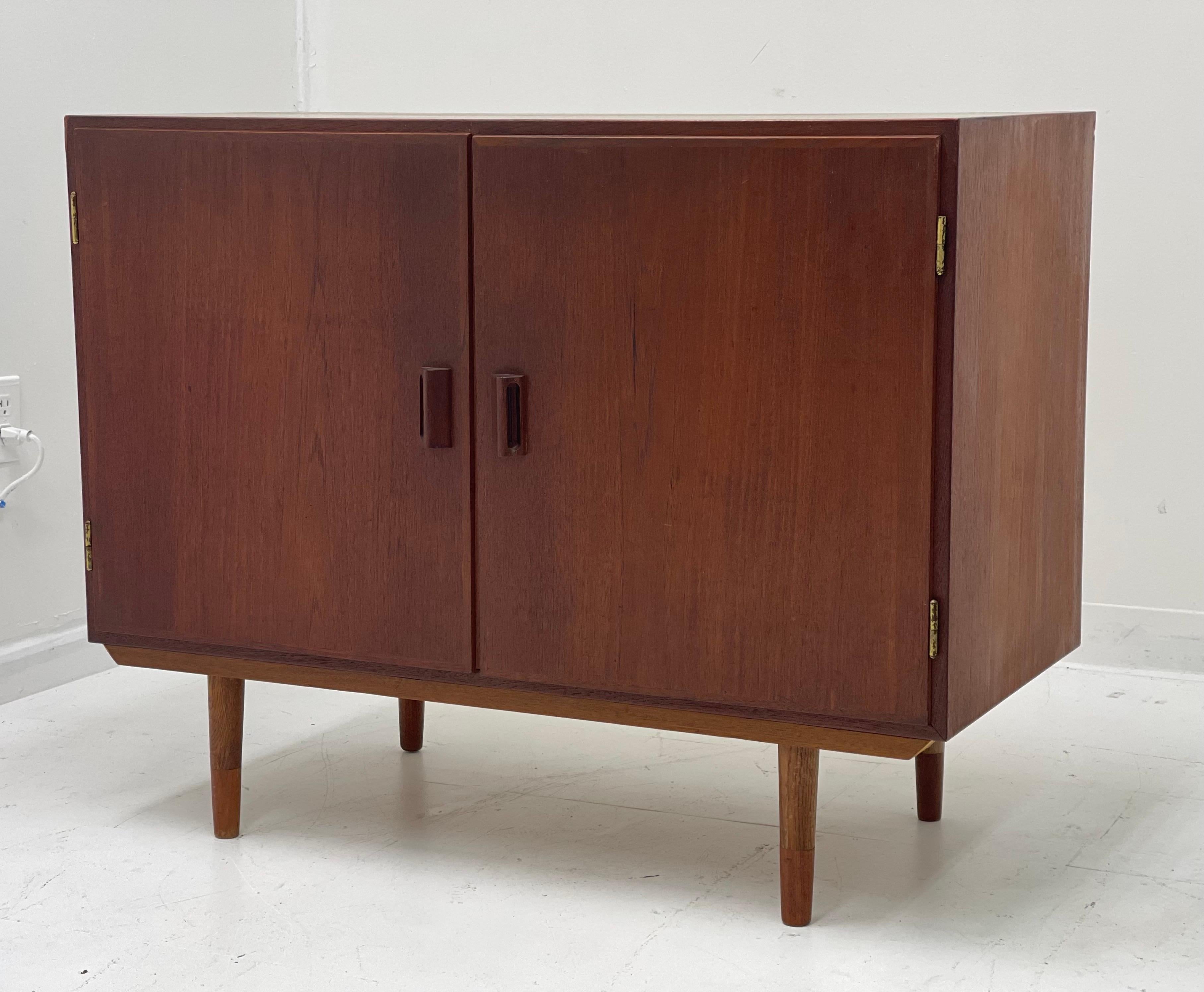 Vintage Danish teak and oak cabinet designed in 1952 by Danish great, Børge Mogensen. Two pull out doors with brass hinges featuring trademark Mogensen solid teak handle pulls, reveals adjustable height shelf with plenty of storage beneath. Labeled