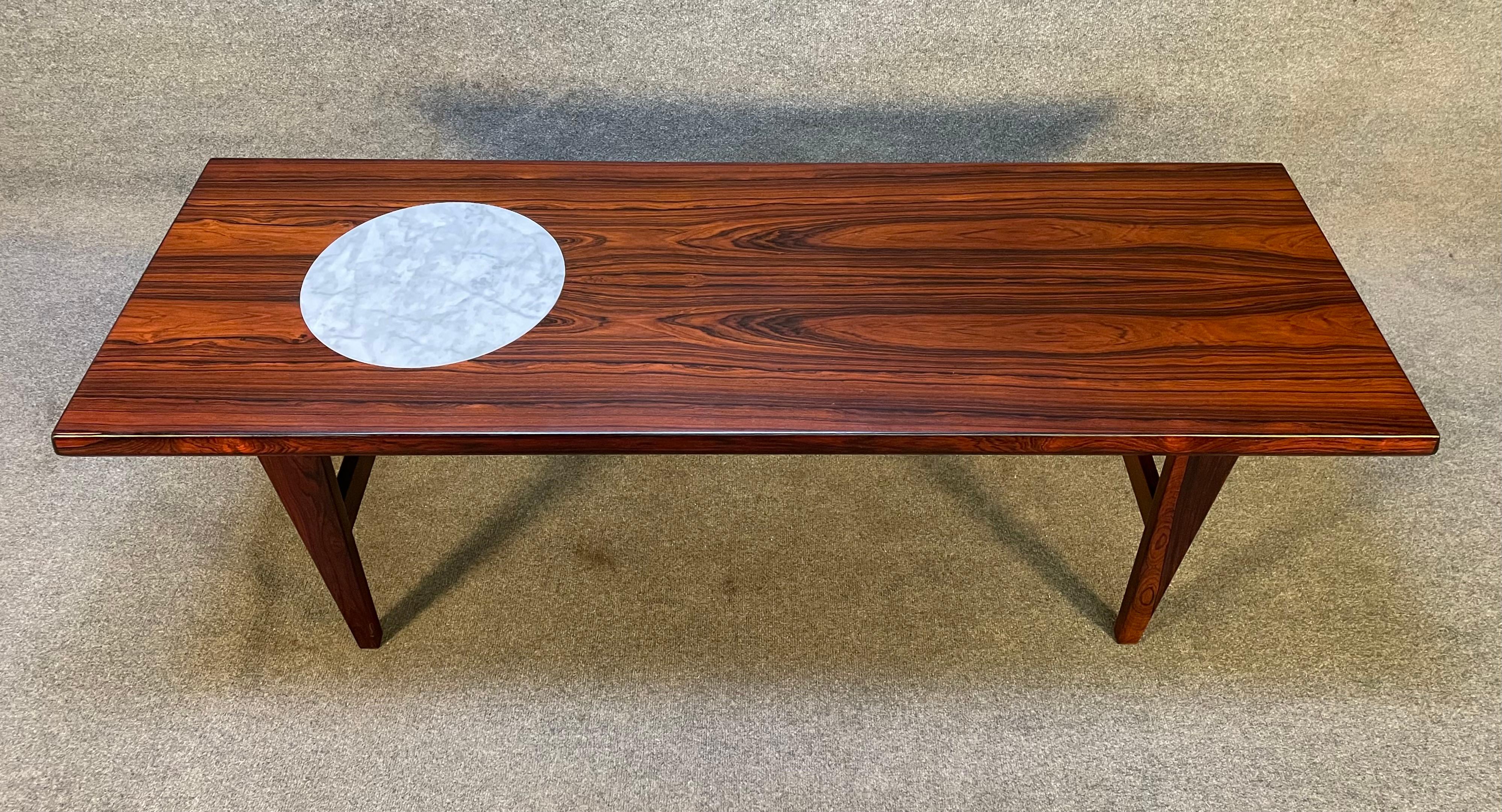 Here is a beautiful 1960's scandinavian modern cocktail table in rosewood manufactured in Denmark recently imported to California before its refinishing.
This special table features a vibrant wood grain, a white marble insert and four sculptural