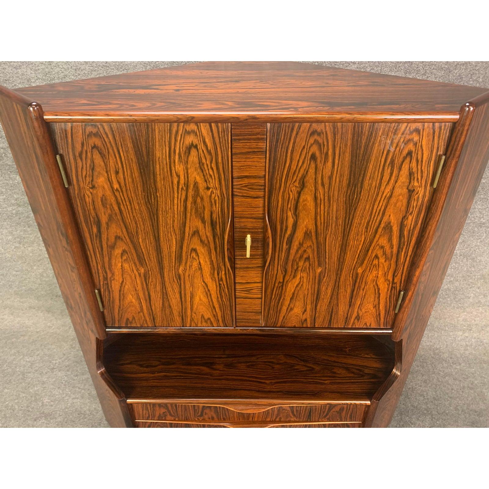 Here is a beautiful Scandinavian Modern corner cabinet in Brazilian rosewood attributed to designer by Gunni Oman and manufacturer by Omann Jun Mobelfabrik, Denmark, 1960s. This special piece features a vibrant wood tone and grain, sculptural pulls