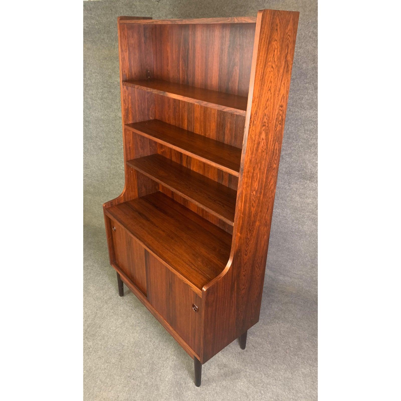 Here is a very sought after Scandinavian Modern bookcase in rosewood designed by Johannes Sorth for Bornholm Møbelfabrik in Nexø, Denmark in the 1960s. This exquisite piece features a vibrant wood grain and a large display area with three adjustable