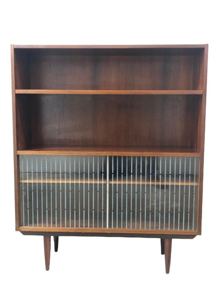 High-quality cabinet from the 1960s. Rosewood case and lower cabinet with two glass sliding doors. Tapered Rosewood feet.

Dimension: 40 W 12 D 48 H.