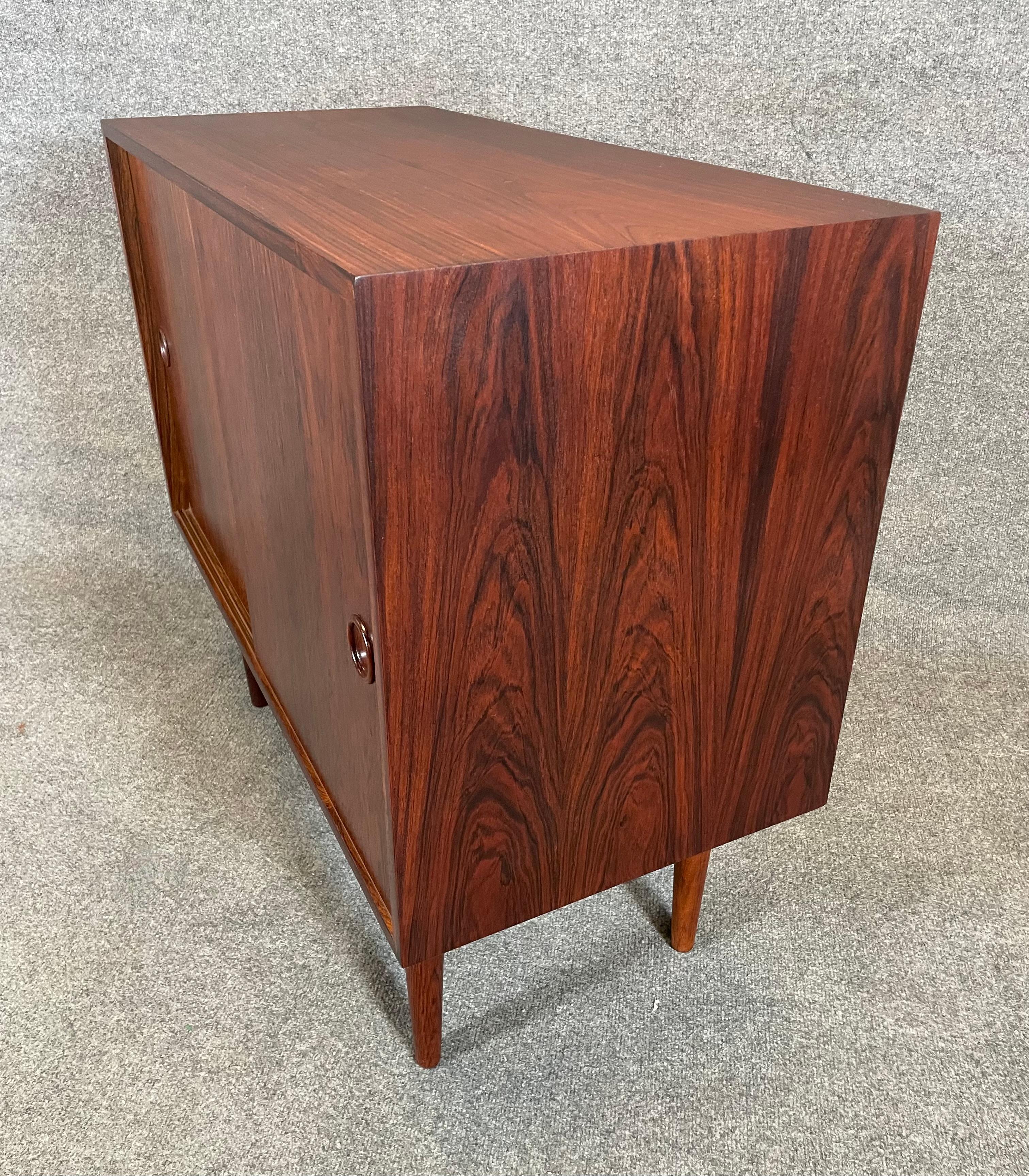 Here is a beautiful Scandinavian modern cupboard cabinet in rosewood designed by Kai Kristiansen and manufactured by Feldballes Mobelfabrik in Denmark in the 1960s. This lovely case piece, recently imported from Europe to California before its