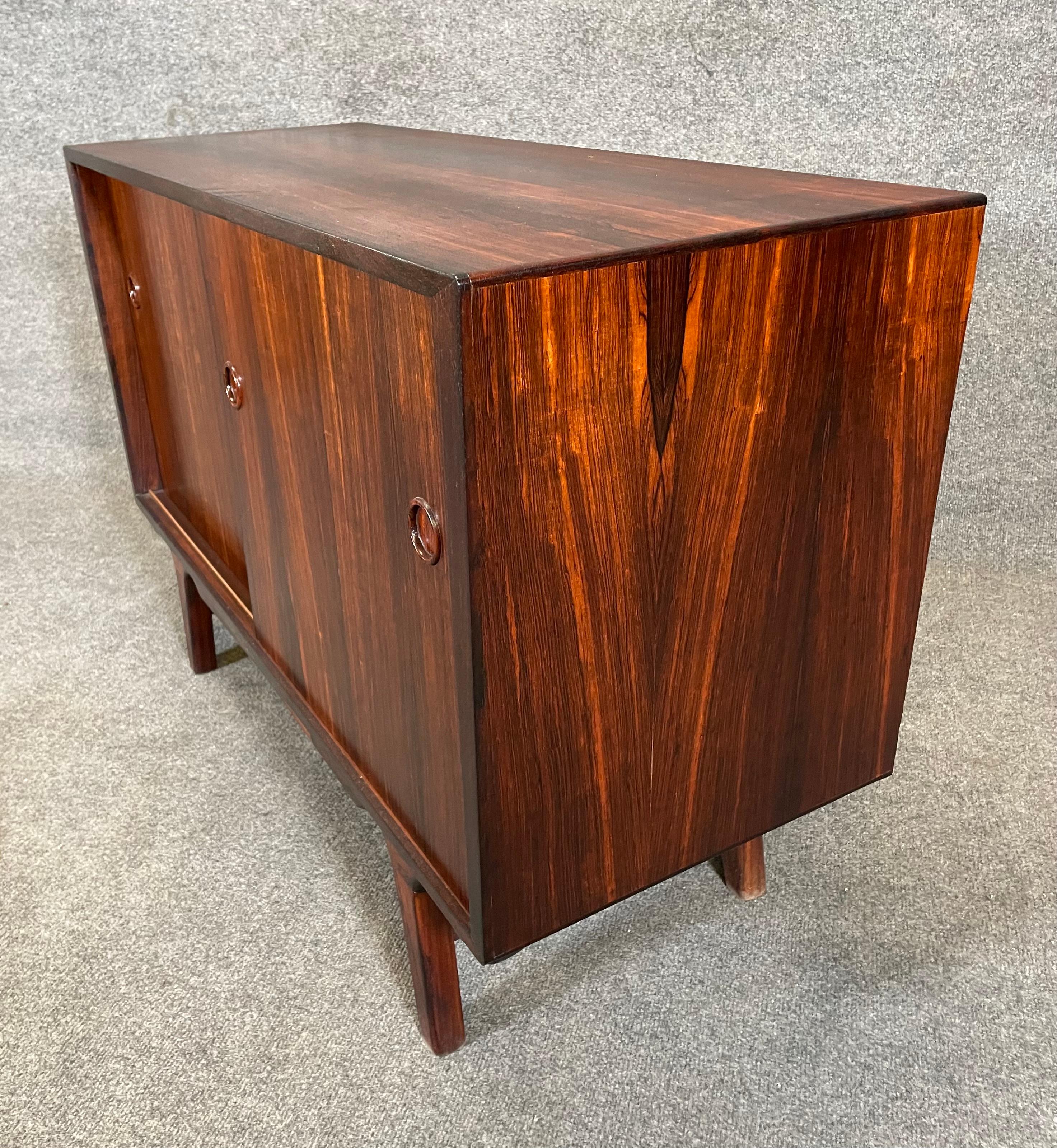 Here is a beautiful scandinavian modern cabinet in rosewood manufactured in Denmark in the 1960's.
This lovely case piece, recently imported from Europe to California before its refinishing, features a vibrant wood grain, two sliding doors revealing