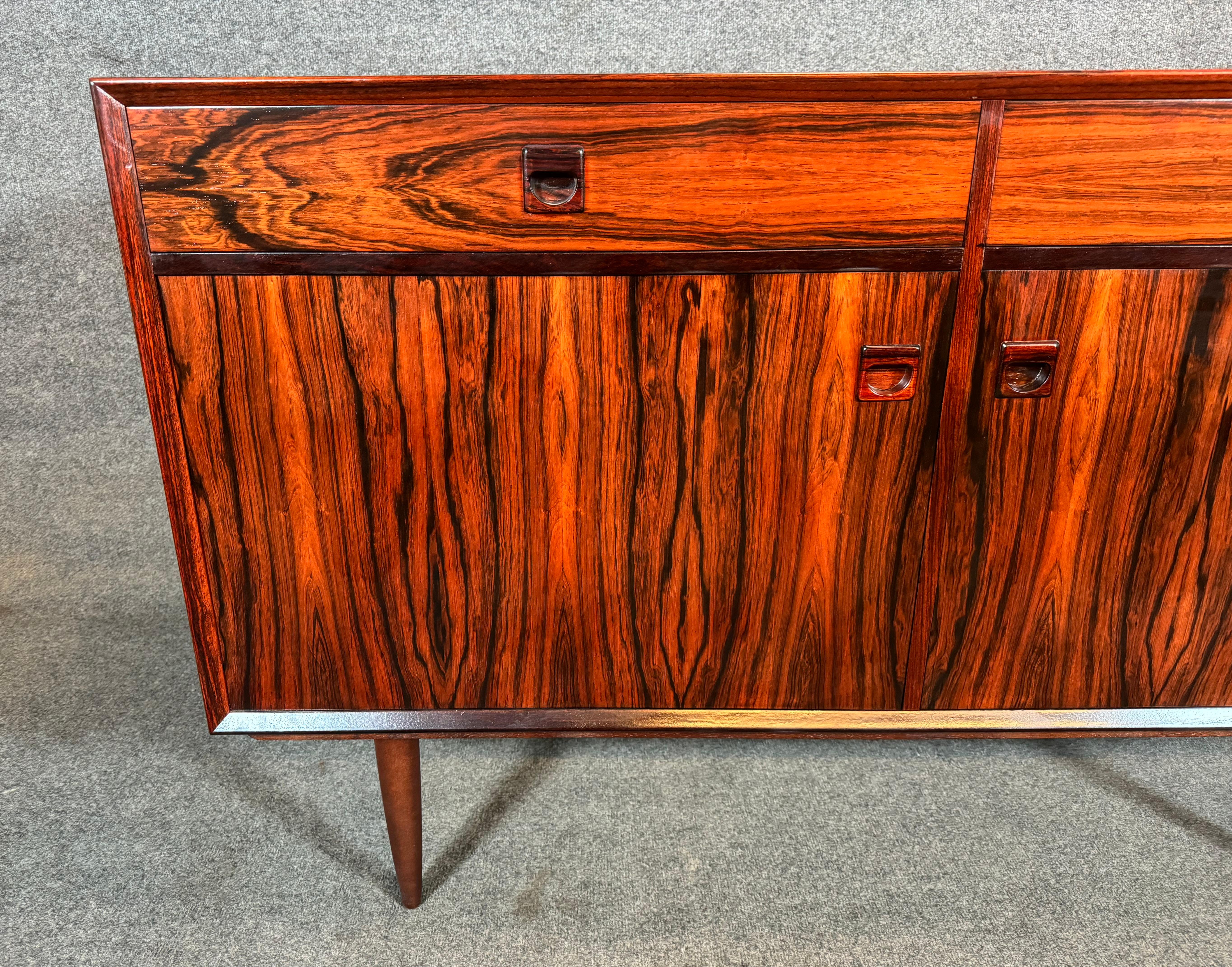 Here is a beautiful scandinavian modern rosewood compact sideboard manufactured by Brouer Mobelfabrik in Denmark in the 1960's. This exquisite piece, recently imported from Europe to California before its refinishing, features a vibrant wood grain,