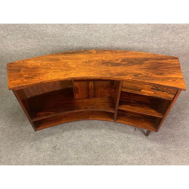 Here is a beautiful 1960s Scandinavian low bar made of rosewood that would be a great addition to your modern interior.
This conversation piece, recently imported from Sweden to California, features a vibrant wood grain, a curved front with a