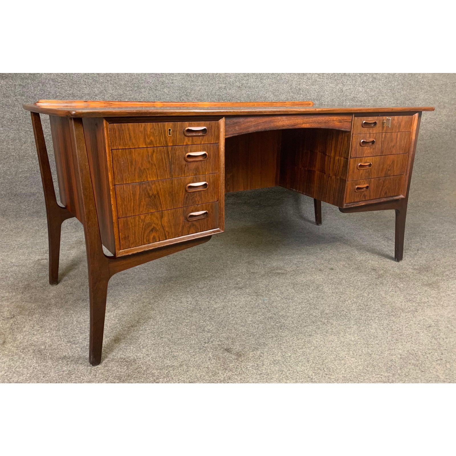 Here's an exclusive Scandinavian Modern executive desk in Brazilian rosewood designed by Svend Madsen and manufactured by HP Hansen in Denmark in the 1960s. This beautiful desk features a bowed large top with vibrant wood grain and a raised lip