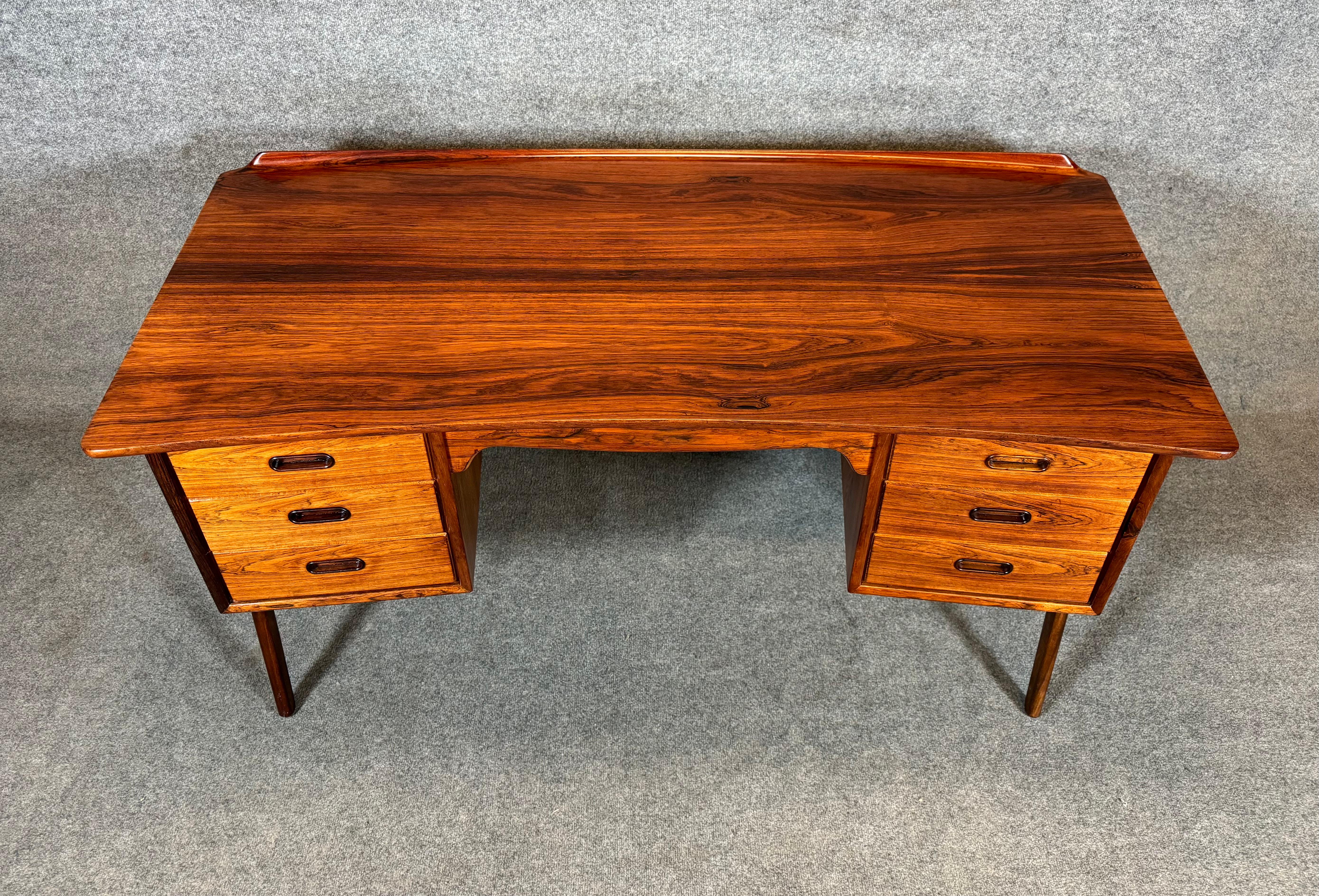 Here is a beautiful and sought after scandinavian modern executive desk in rosewood designed by Svend Madsen and manufactured by HP Hansen in Denmark in the 1960's. This special desk, recently imported from Europe to California before its