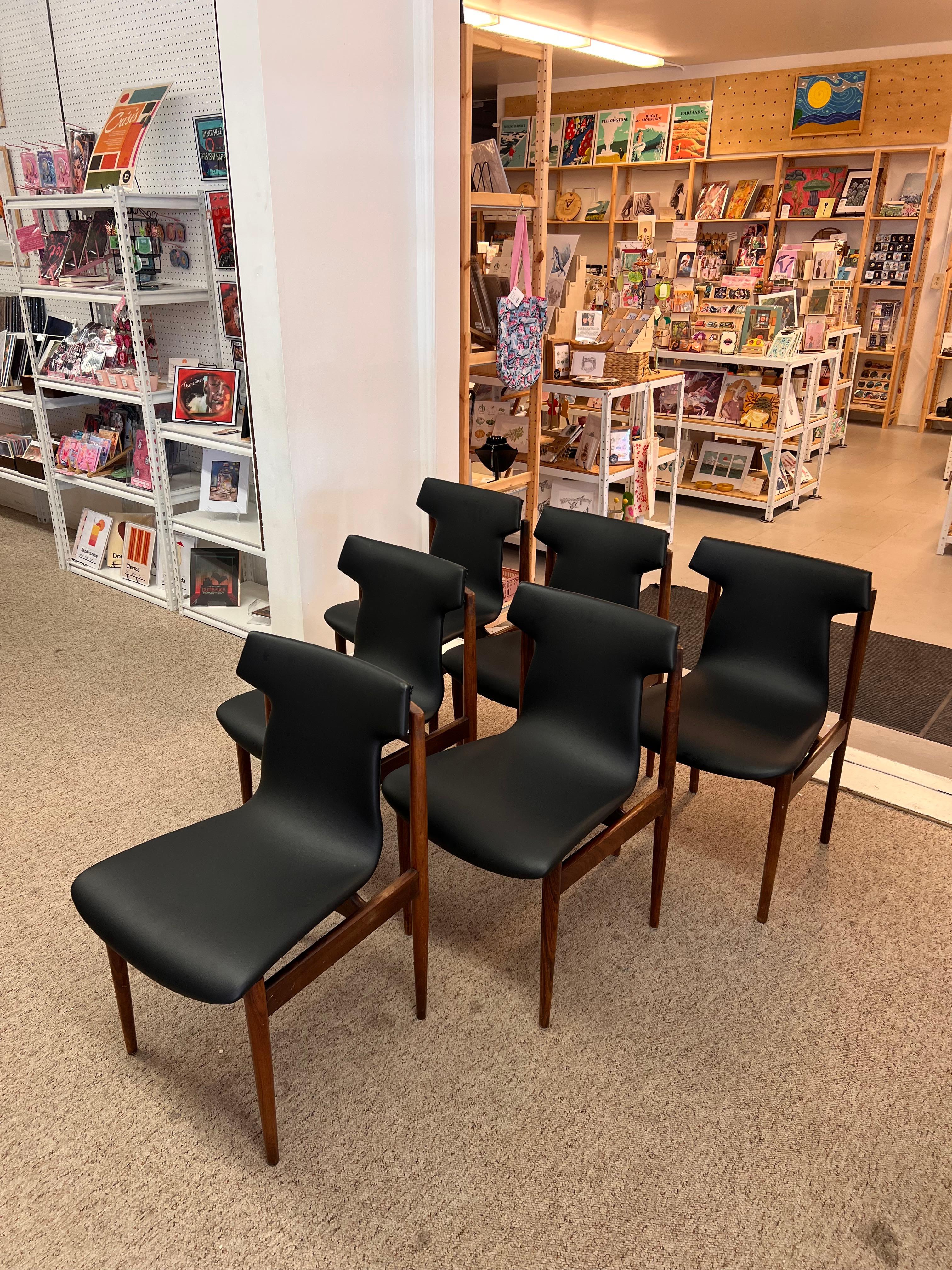  This Danish mid-century modern chair features a sleek design characterized by clean lines and a minimalist aesthetic. The chair has a wooden frame, made from a rich, warm-toned rosewood hardwood, showcasing the craftsmanship typical of the era.
The