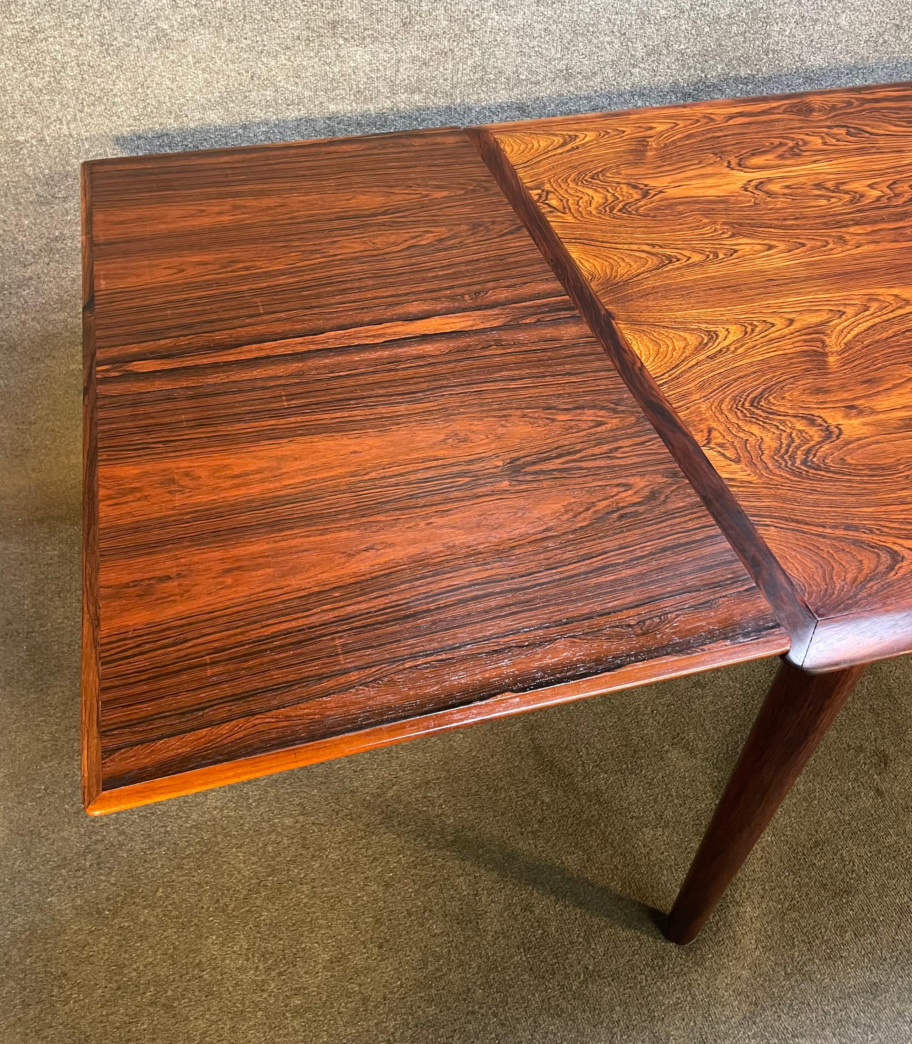 Here is a beautiful scandinavian modern dining table in rosewood manufactured in Denmark in the 1960's.
This superb table, recently imported from Europe to California before its refinishing, features amazing wood grain details, two draw leaves and