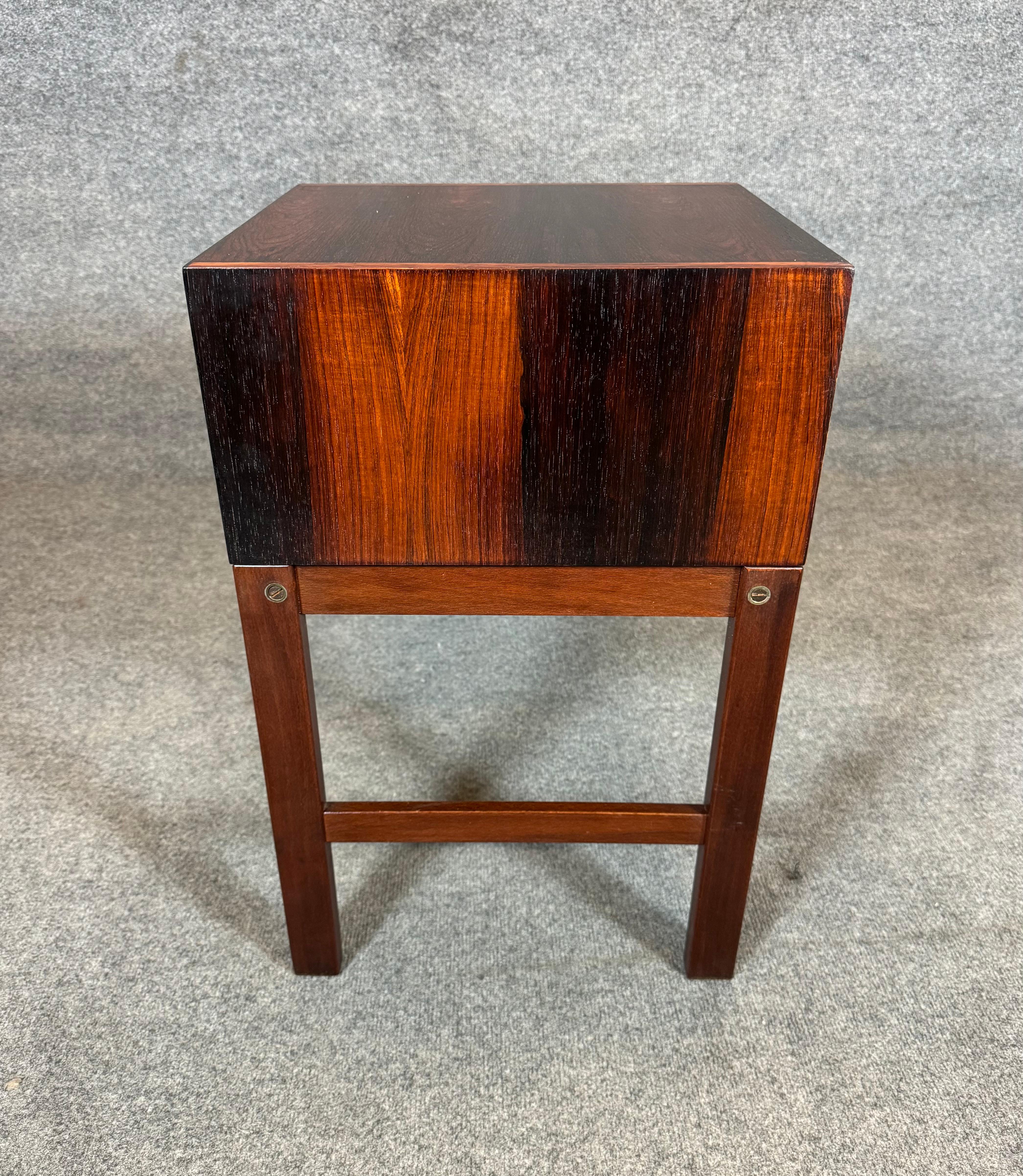 Here is a beautiful Scandinavian modern entry way/telephone bench in rosewood manufactured in Denmark in the 1960's.
This exquisite piece, recently imported from Europe to California before its refinishing, features a seating area with a brand new