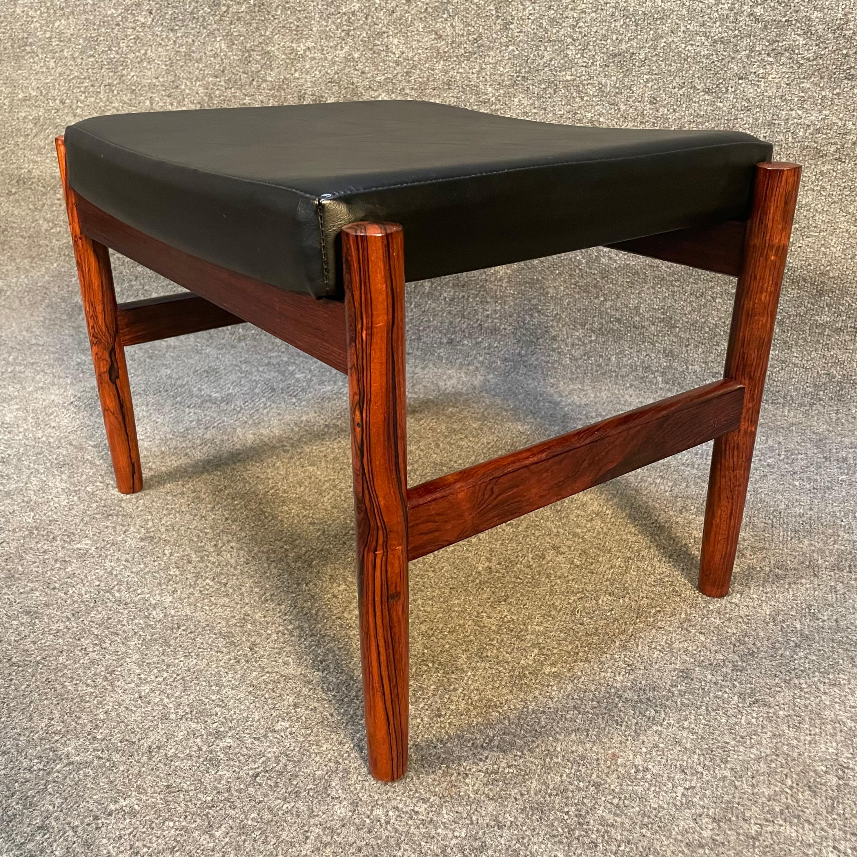 Here is a beautiful scandinavian modern footstool in rosewood manufactured by Spottrup in Denmark in the 1960's.
This exquisite ottoman, recently imported from Europe to California before its refinishing, features a solid rosewood frame and a seat