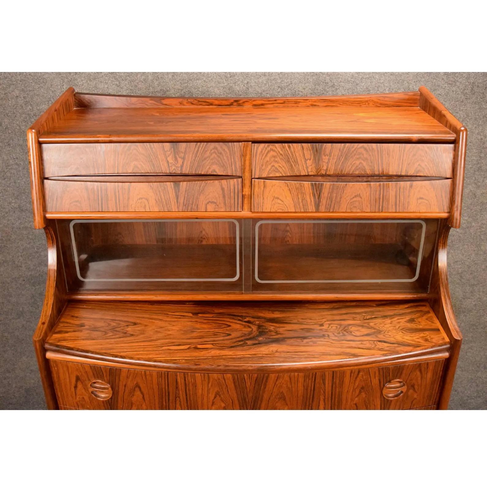 Here is a beautiful scandinavian modern secretary desk in rosewood manufactured by Falsig Mobler in Denmark in the 1960's. This special case piece, recently imported from Europe to California, features a vibrant wood grain, four small drawers, a