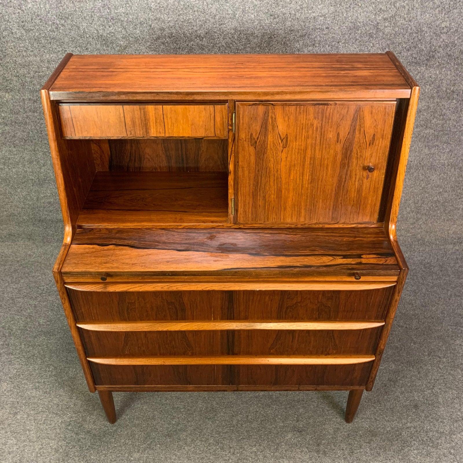 Here is a beautiful Scandinavian Modern secretary desk in rosewood manufactured in Denmark in the 1960s.
This case piece features a vibrant wood grain, a small drawer and cubby on its top plus a door opening to reveal an extra storage space and a