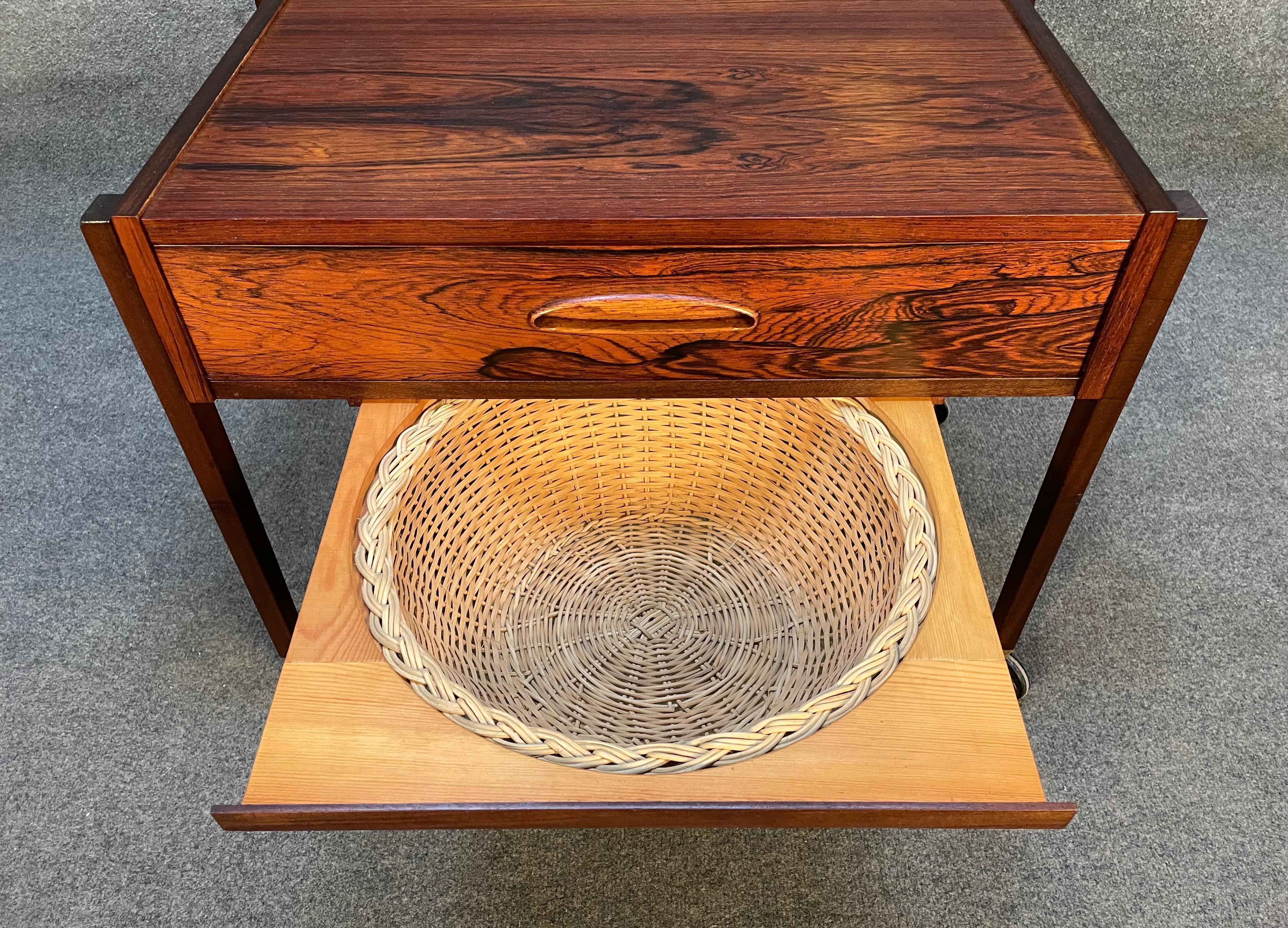 Here is a beautiful Scandinavian modern sewing cart in Brazilian rosewood manufactured in Denmark in the 1960's recently imported to California before its refinishing.
This lovely piece features a vibrant wood grain, a single drawer with a recessed