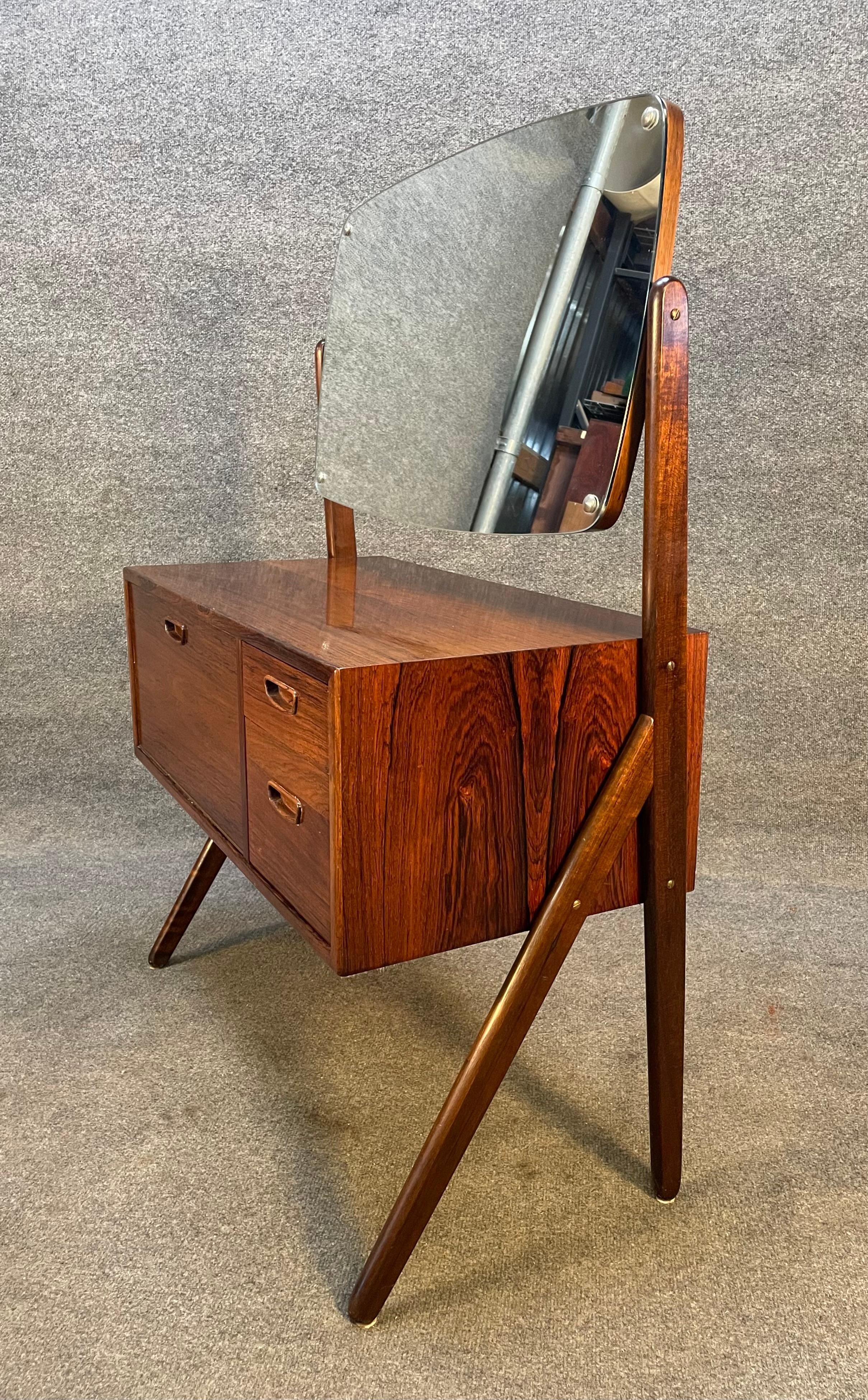 Here is a stunning dressing table/vanity in rosewood designed by Sigfred Omann in the 1960's and manufactured in Denmark. Beautiful rosewood grain through.
This exquisite piece features a tilting mirror in excellent condition, a set of 