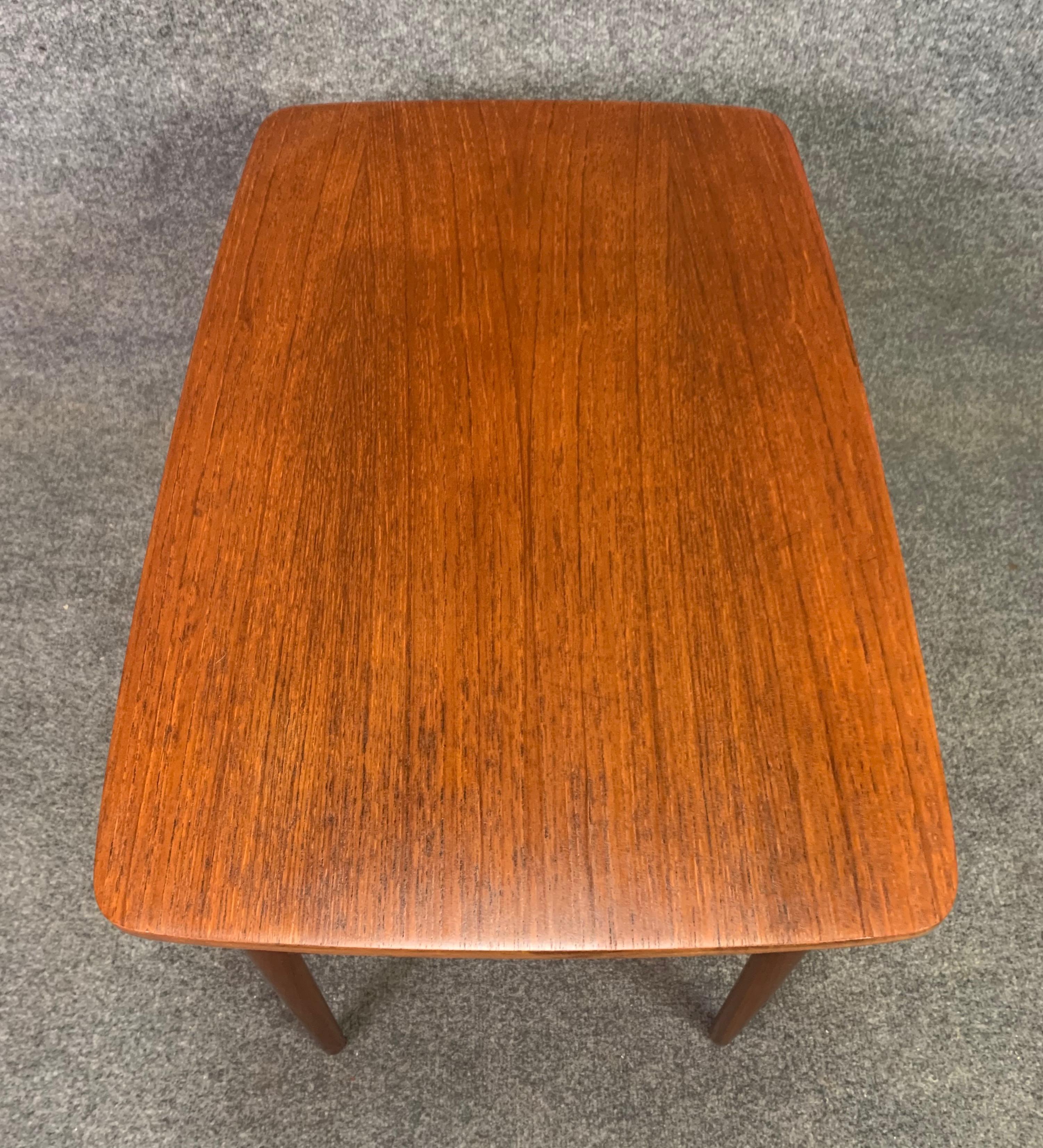 Here is a lovely 1960s Scandinavian Modern end table in teak recently imported from Denmark to California before its refinishing.
This side table features a vibrant teak wood grain, one cane shelf and four tapered legs.
Excellent