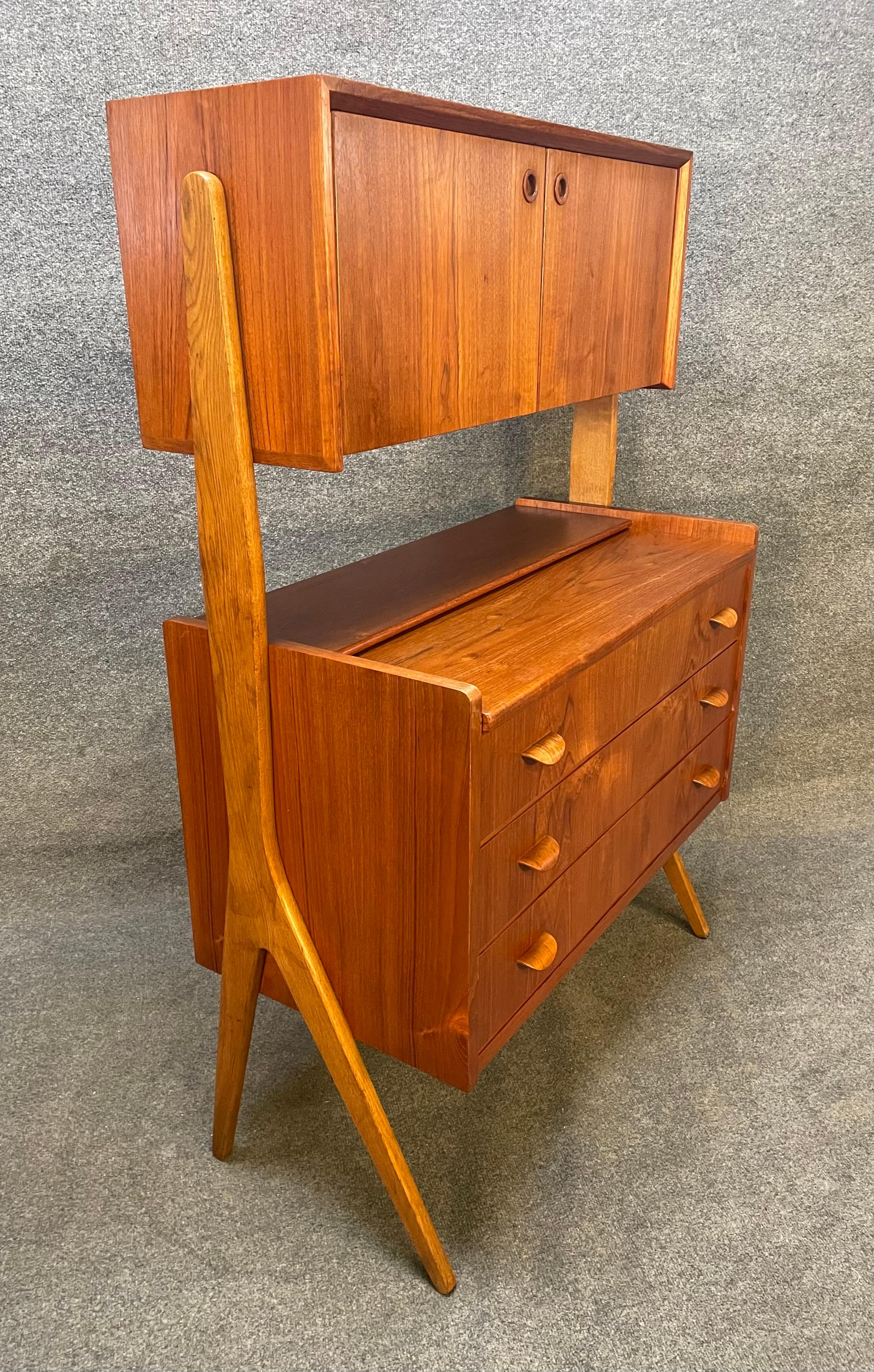 Here is a rare scandinavian modern secretary/desk/vanity manufactured in Denmark in the 1960's that was recently imported to California before its restoration.
This stunning piece, showing vibrant teak and oak grain, features a solid V frame frame,