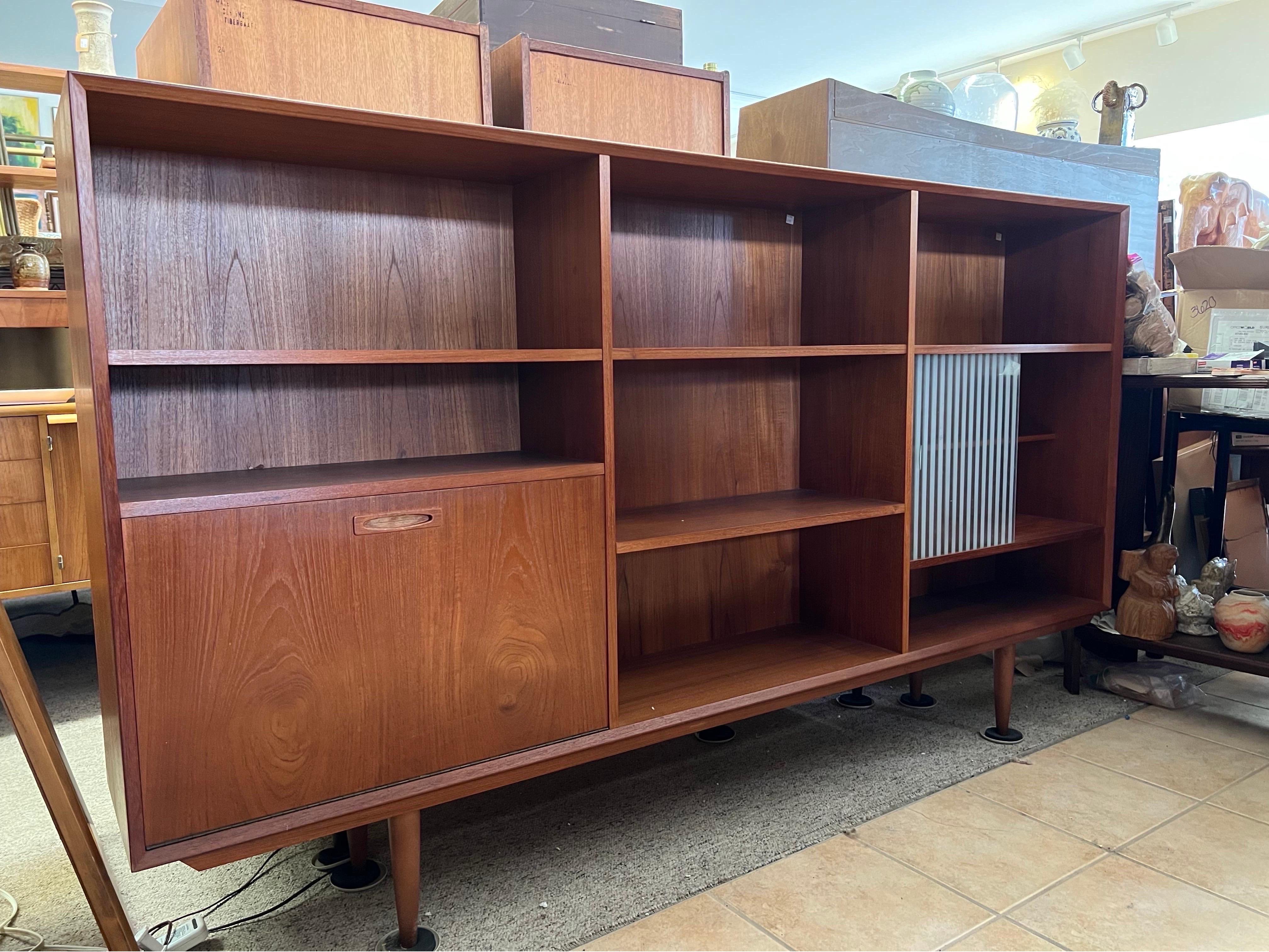 Vintage Danish Mid-Century Modern teak bookcase or bar unit
Dimensions. 79 W ; 44 1/2 H ; 12 D

( Middle Column Shelf are Adjustable)

Right Top 25 W ; 11 H ; 11 D

Right Middle. 25 W ; 15 H ; 11 D

Right Bottom. 25 W ; 6 H ; 11 D

Left