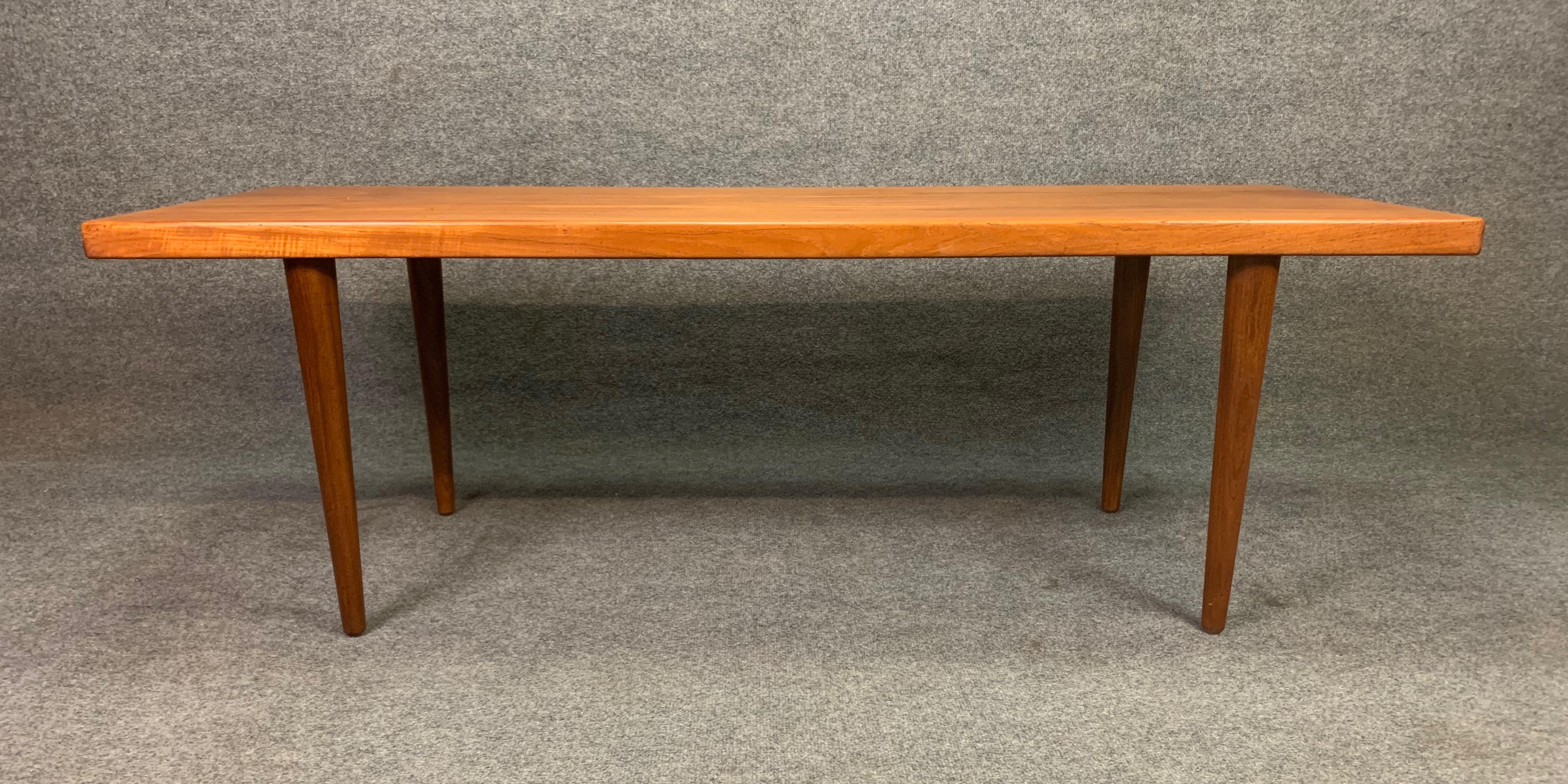 Here is a beautiful 1960s Minimalist surfboard coffee table in teak wood recently imported from Denmark to California before its restoration.
This table features a large top with vibrant wood grain details and rests on four solid tapered teak
